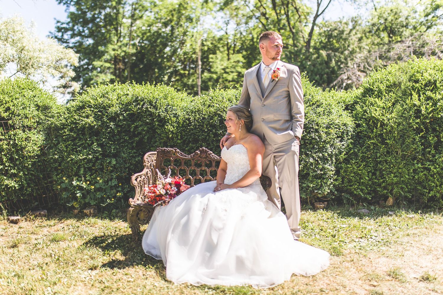 Wedding portraits taken in a garden setting with stone walls and lush greenery.