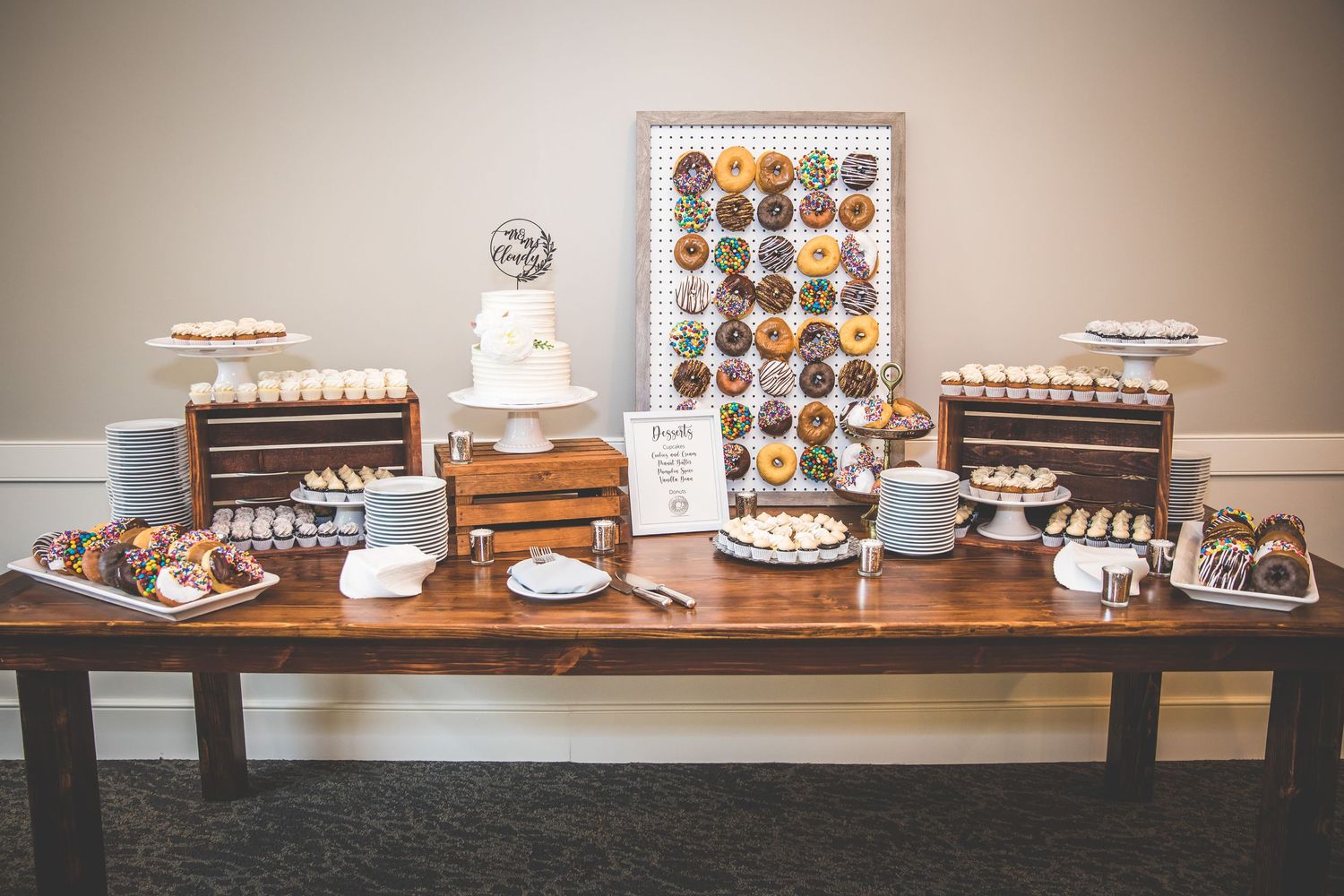 Rustic wooden dessert table display featuring various treats and decorative elements.