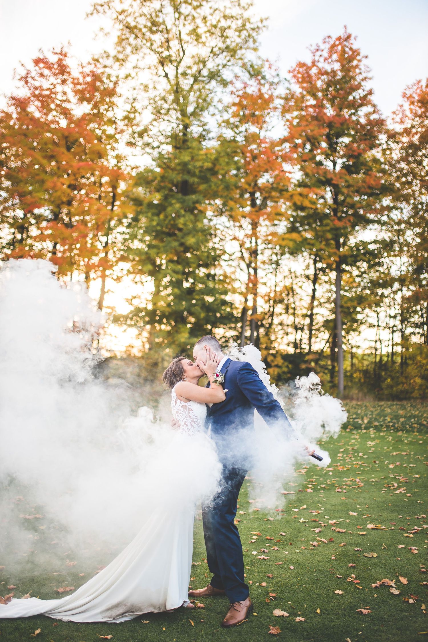 Artistic wedding photos with smoke effects and fall foliage in the background.