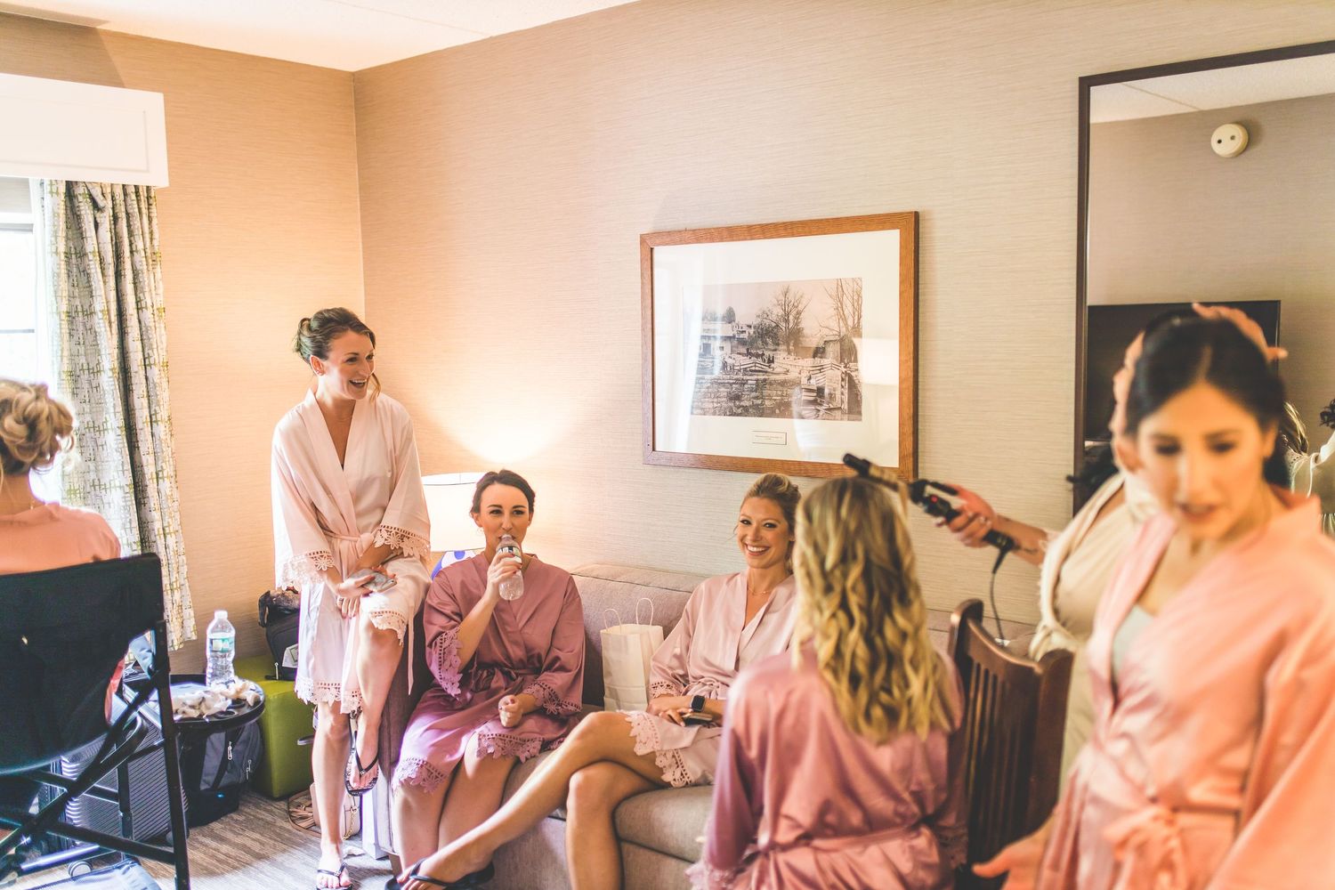 Candid moments of wedding party getting ready in matching pink robes.