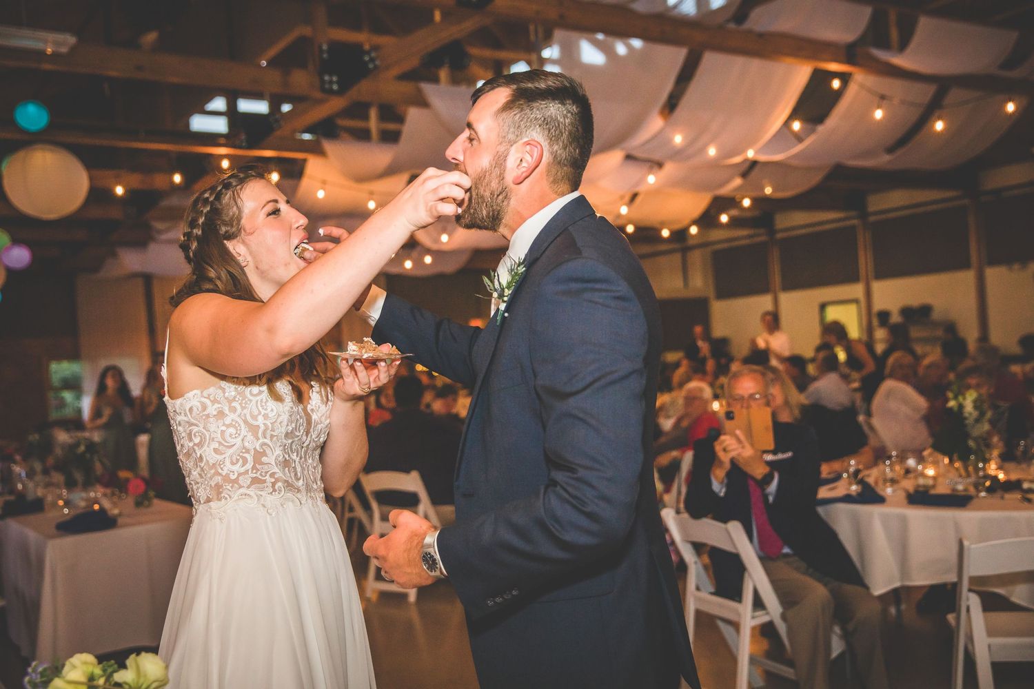 Indoor wedding reception with string lights and festive decorations.