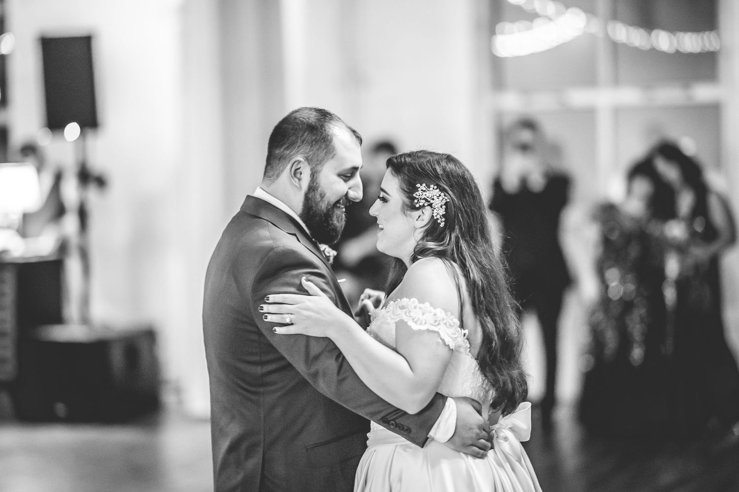 Black and white photo of a romantic dance moment at an elegant wedding reception.