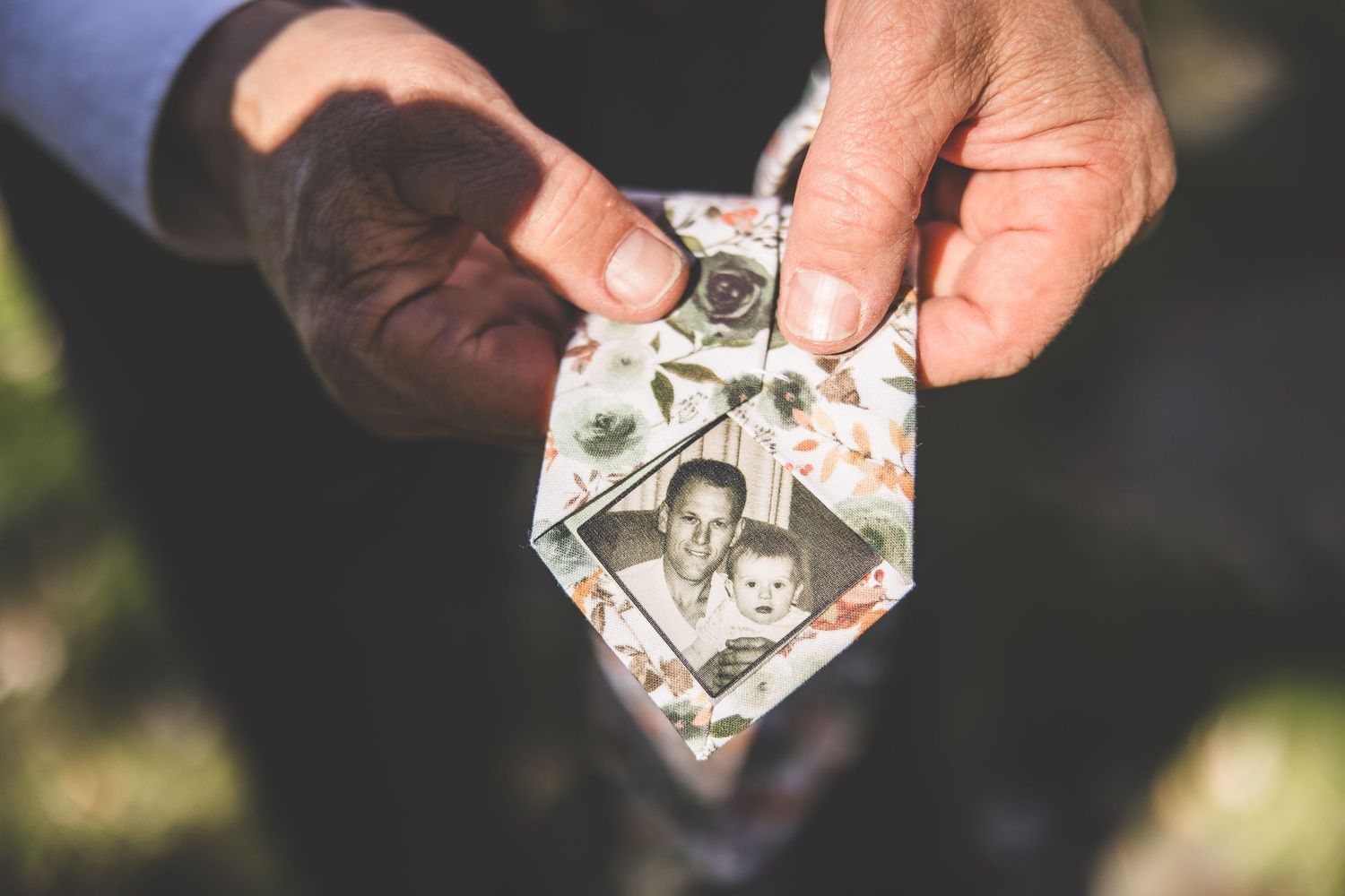 Hands holding and displaying vintage black and white photographs.