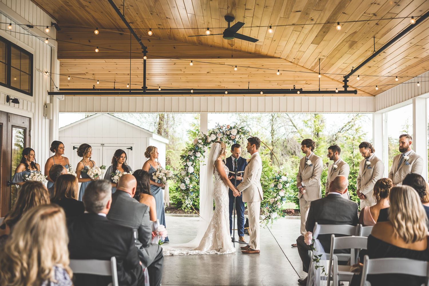 Panoramic view of wedding ceremony space with wooden ceiling and natural light.