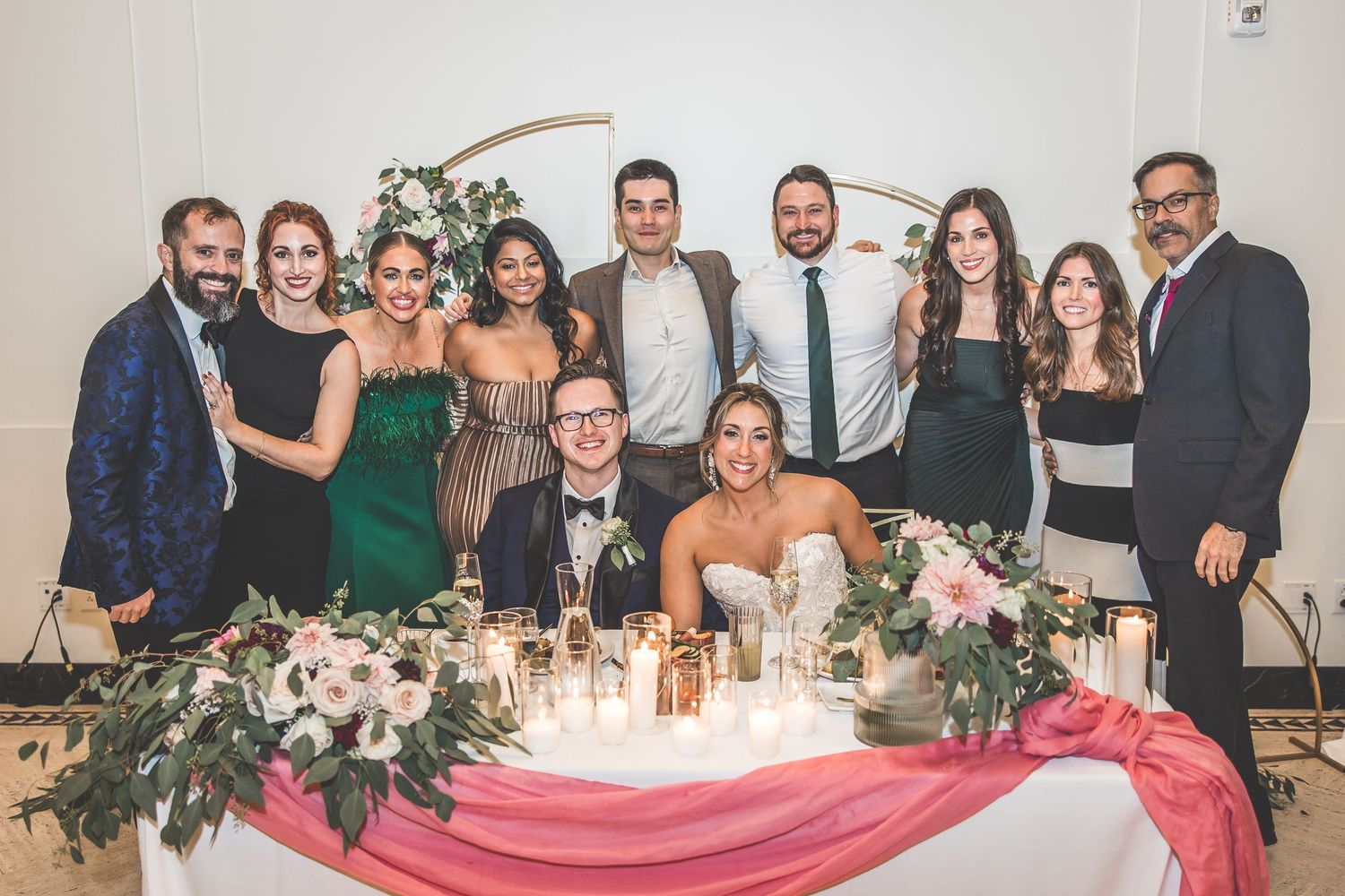 Wedding reception venue with long tables decorated with floral arrangements and romantic lighting.