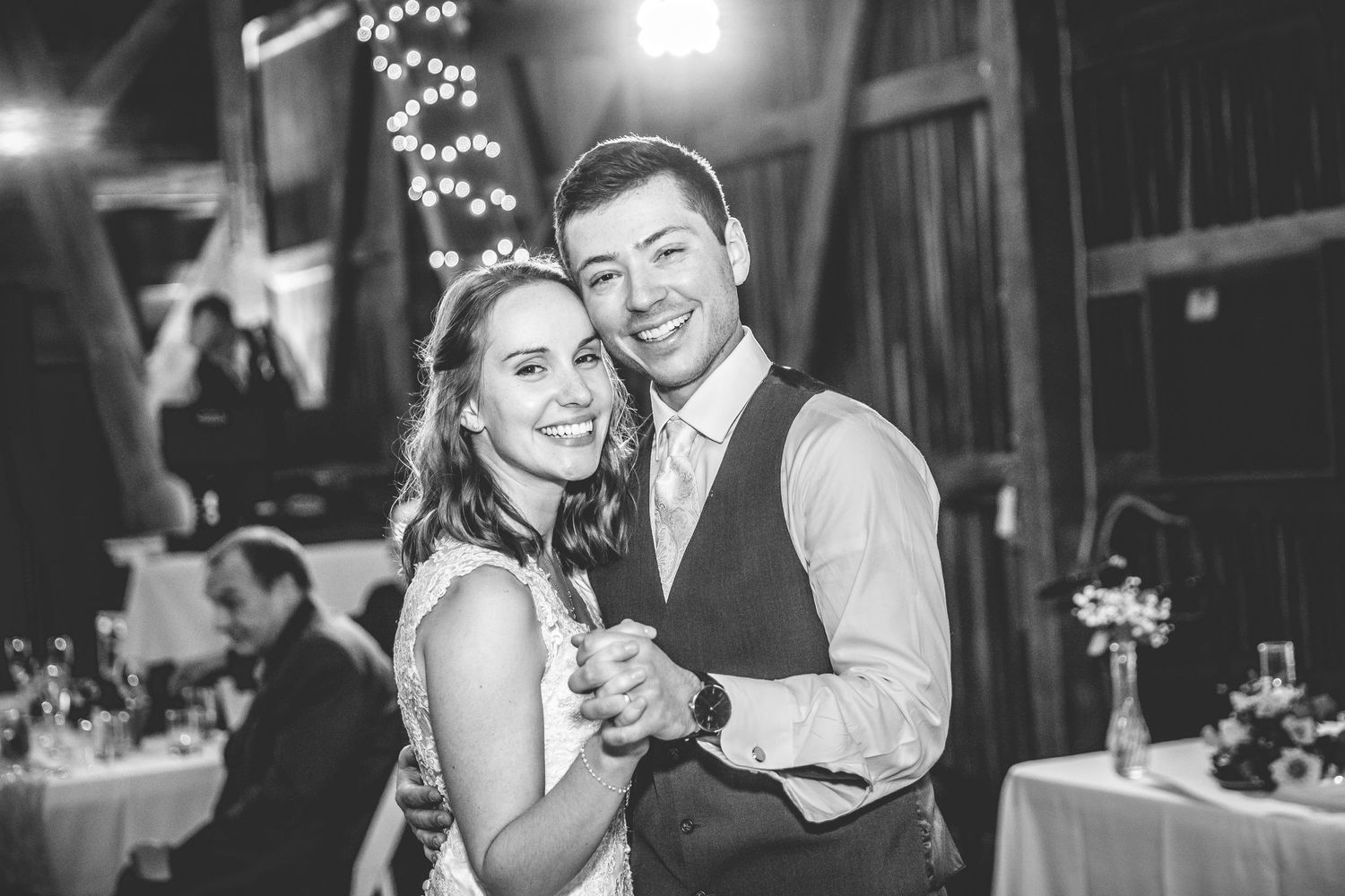 Black and white photos capture joyful dancing moments at an indoor wedding reception.