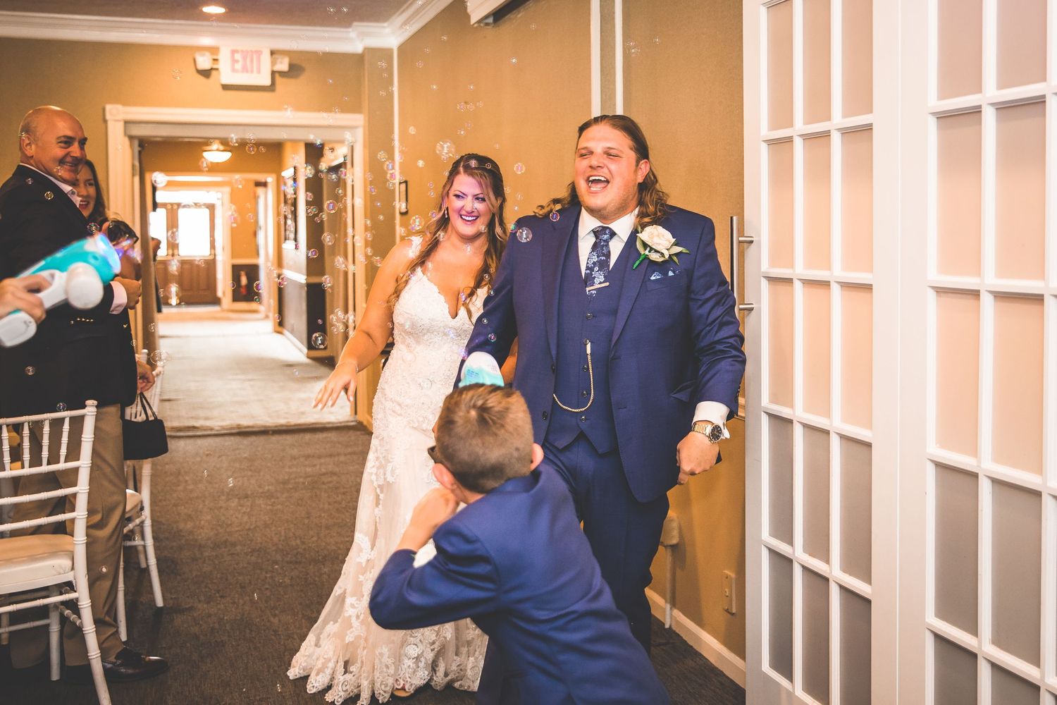 Indoor wedding venue decorated with white and natural light streaming through windows.