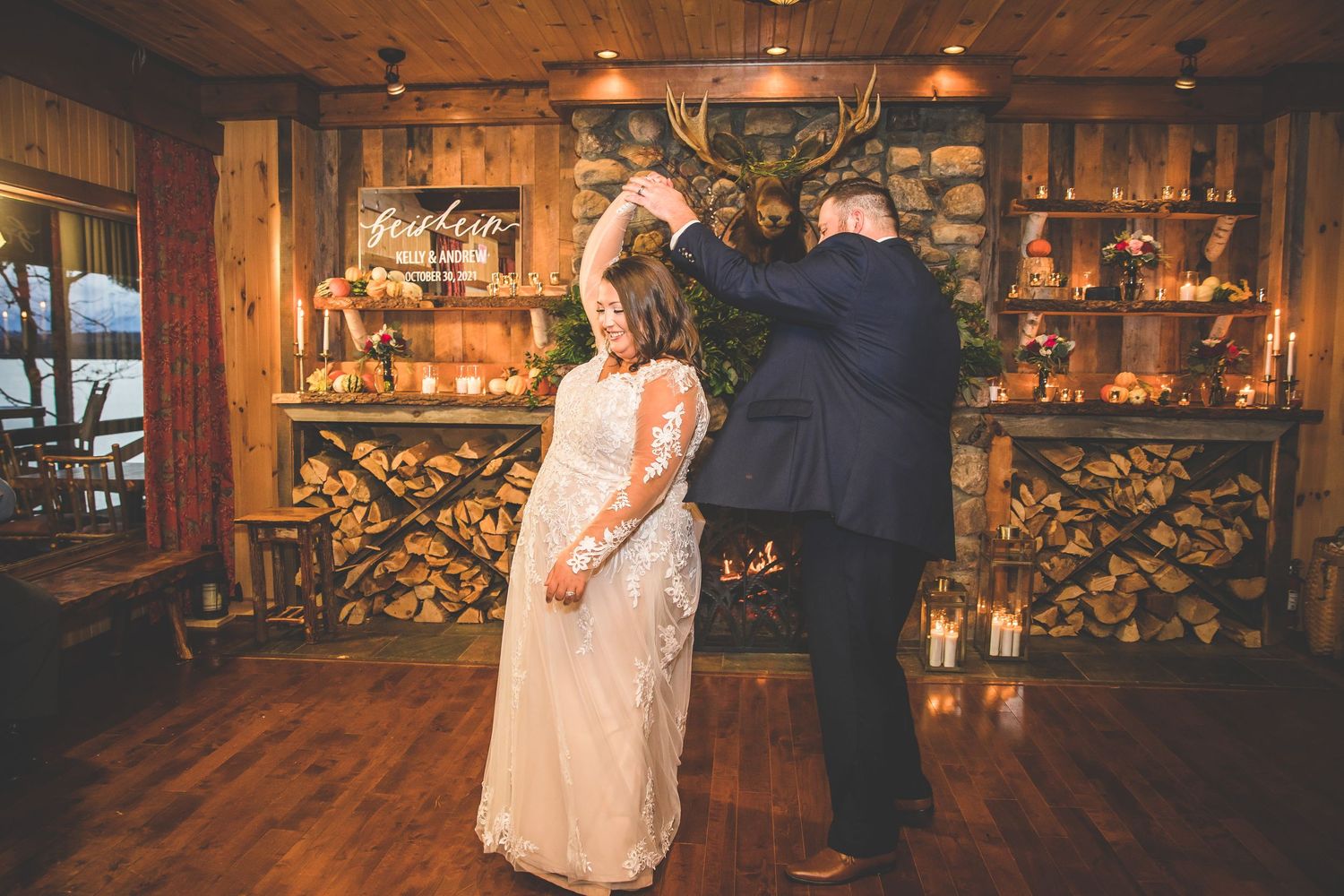 Wedding couple sharing first dance in rustic wooden lodge venue.