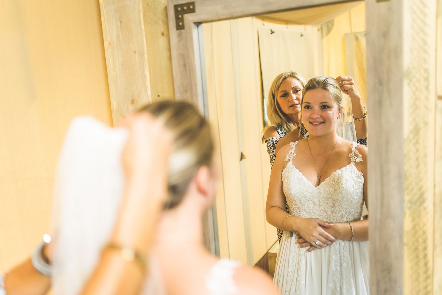 Bridal preparations taking place in a room with warm yellow lighting.