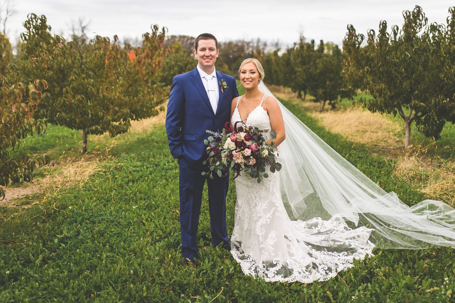 Romantic outdoor wedding photos captured in a scenic natural setting with flowing veil.