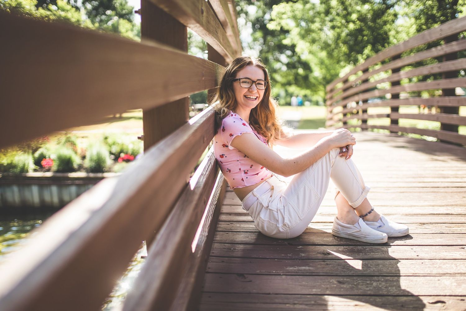 Playful engagement photos on wooden bridge walkway in natural setting.