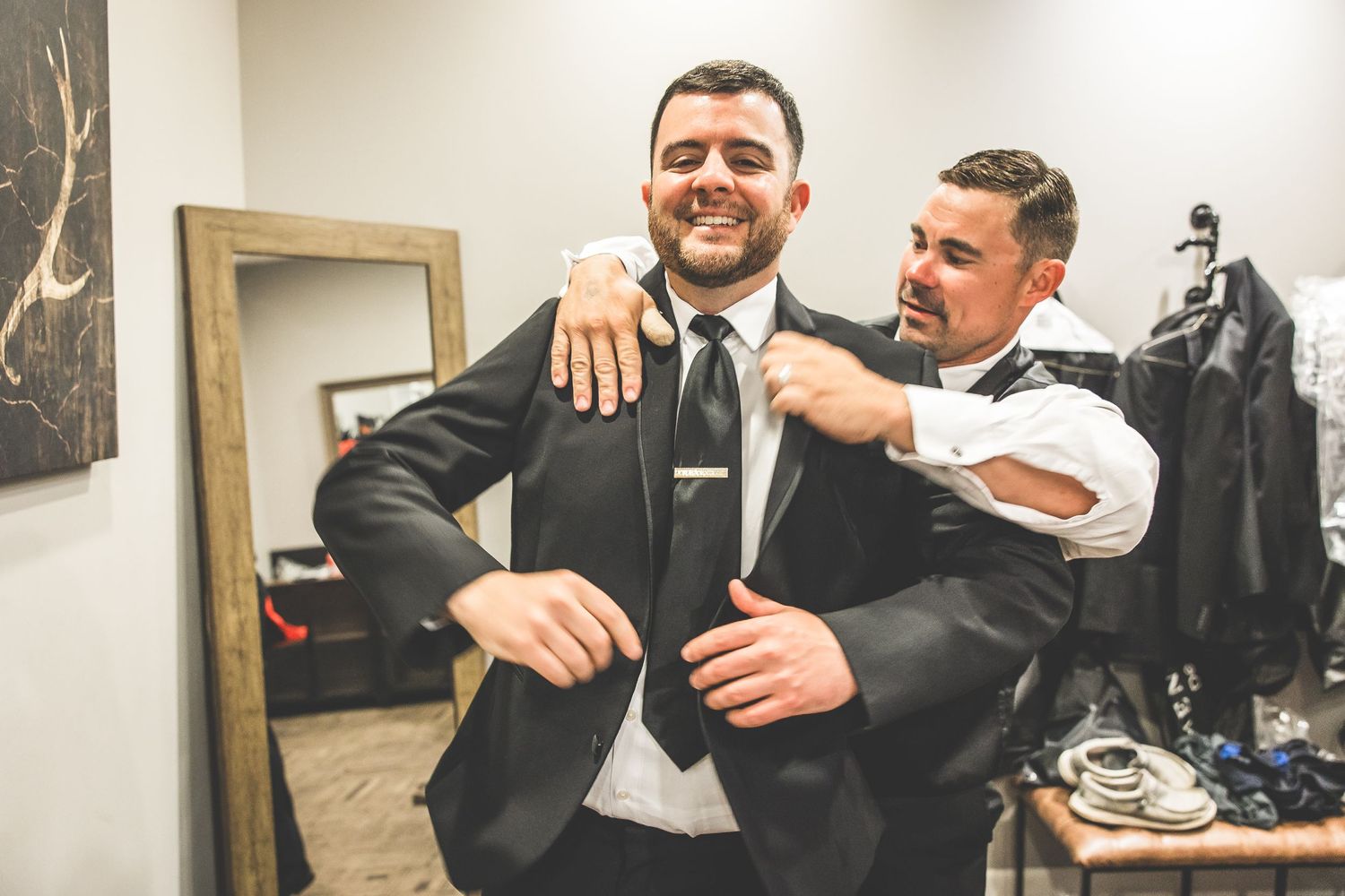 Pre-wedding moments captured in the getting ready room with formal attire.