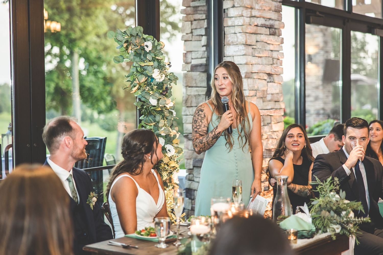 Wedding reception venue decorated with floral arrangements and string lights.