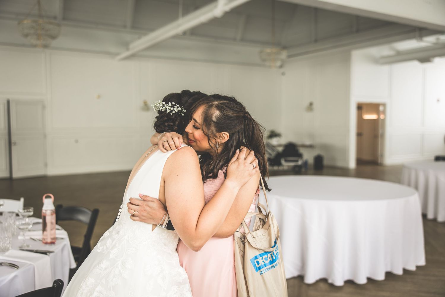 Wedding preparation scene in white industrial venue space.