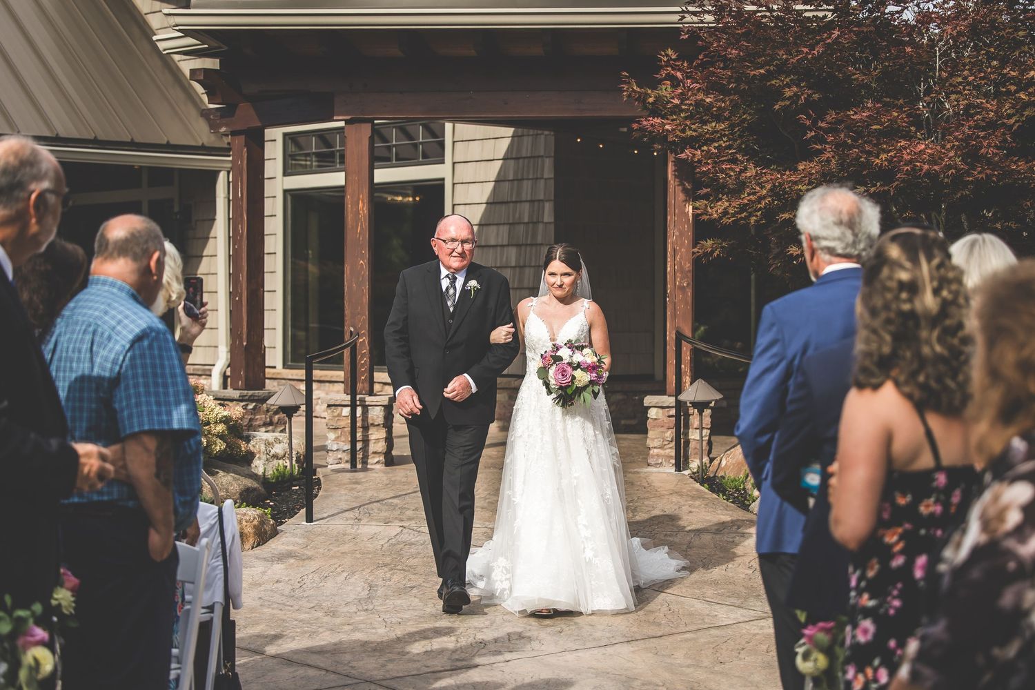 Wedding guests mingling during outdoor reception on stone patio.