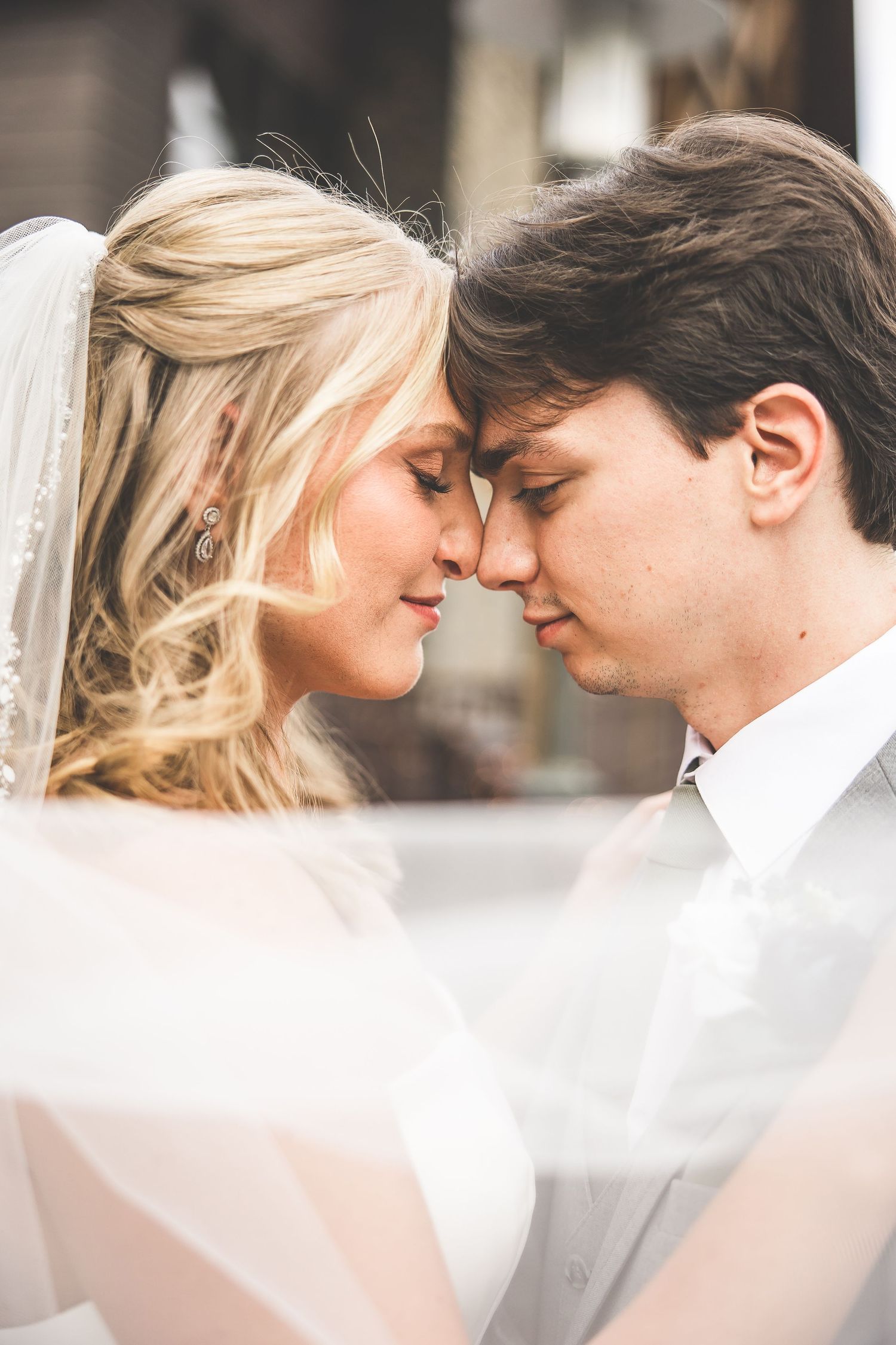 Intimate close-up portrait of wedding couple with soft focus and dreamy lighting.
