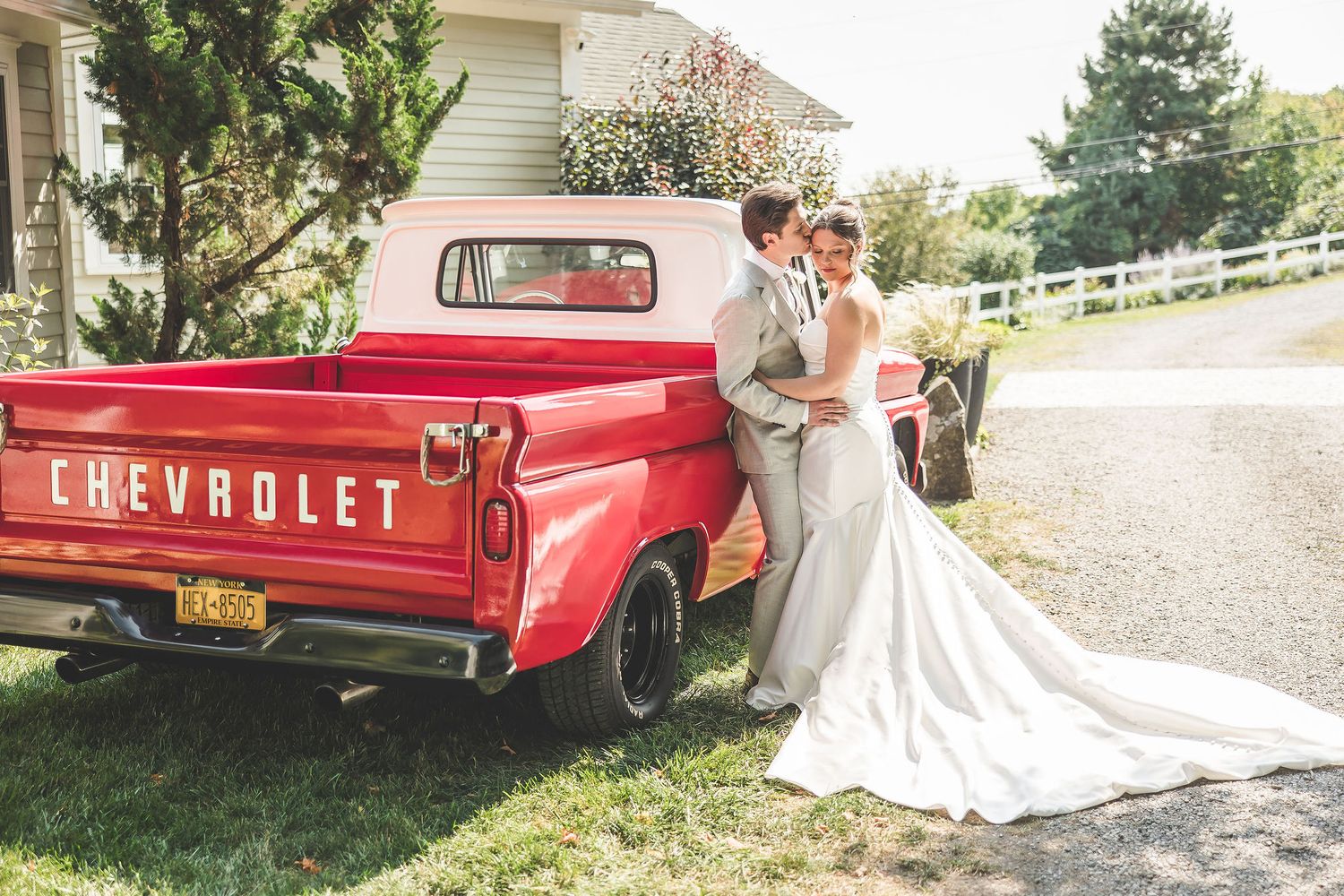 Romantic wedding photos featuring a classic red Chevrolet pickup truck and elegant white dress against a rustic backdrop.
