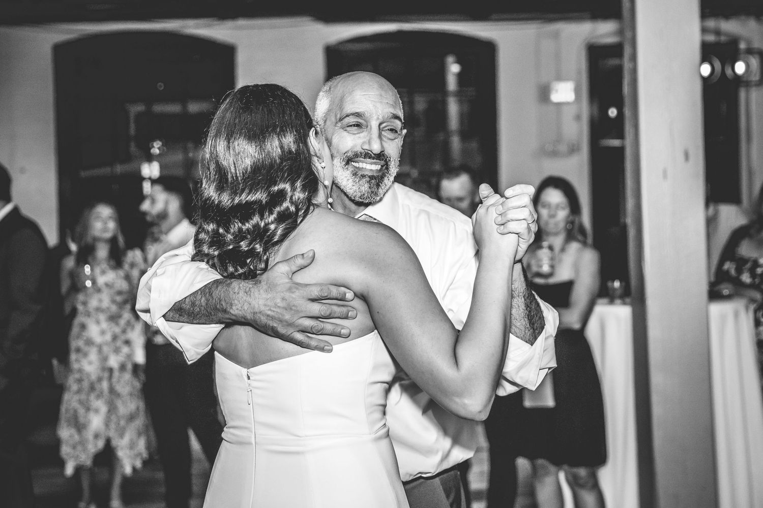 Black and white photo of a couple dancing at their wedding reception.