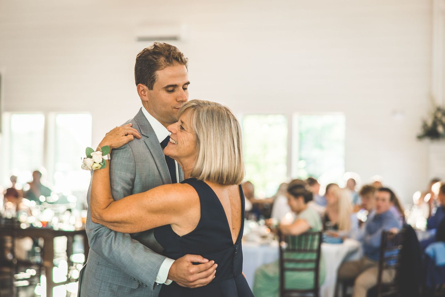 A tender moment between two dancers at an elegant indoor reception venue.