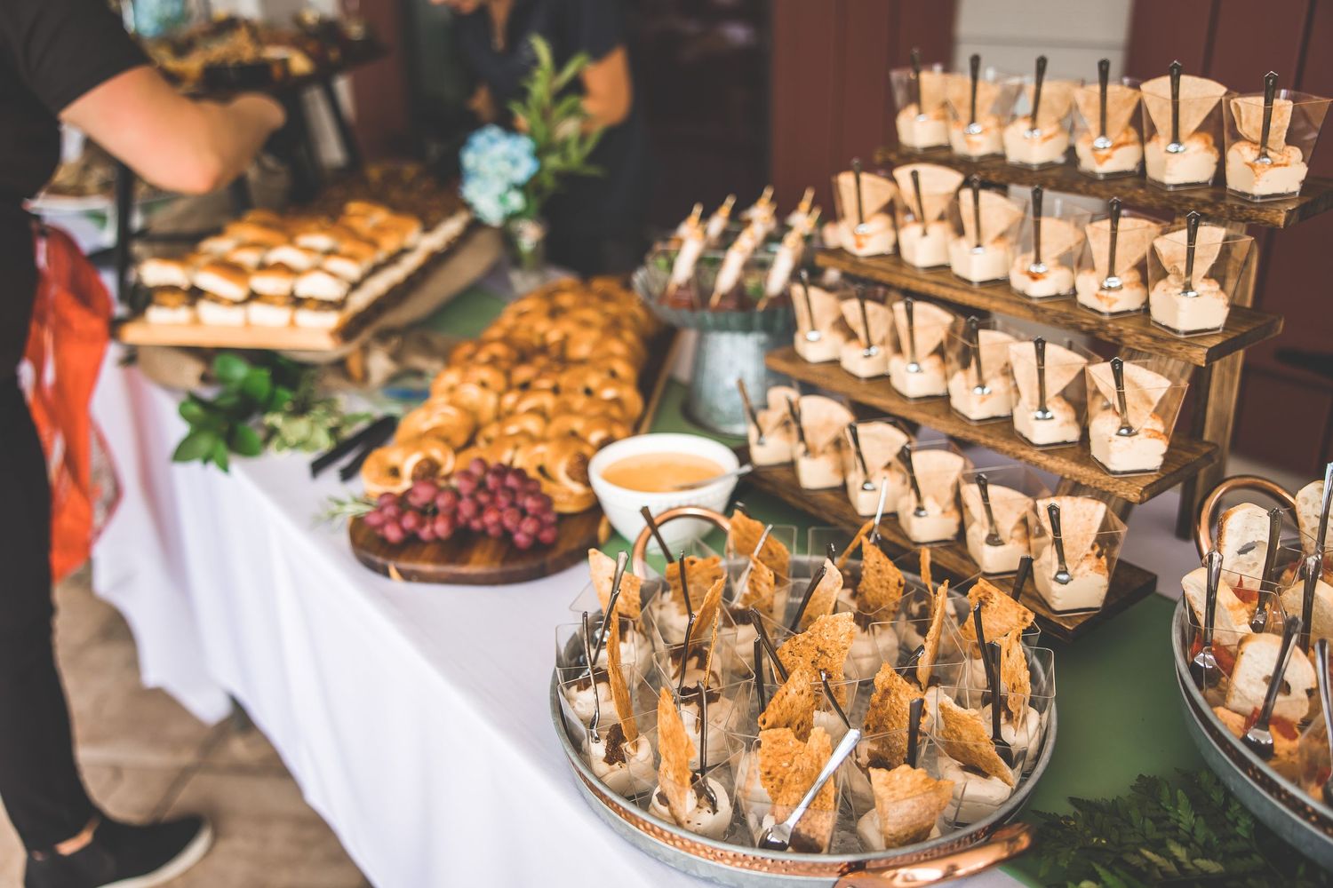 Catering display featuring various appetizers and hors d'oeuvres on decorated buffet table.