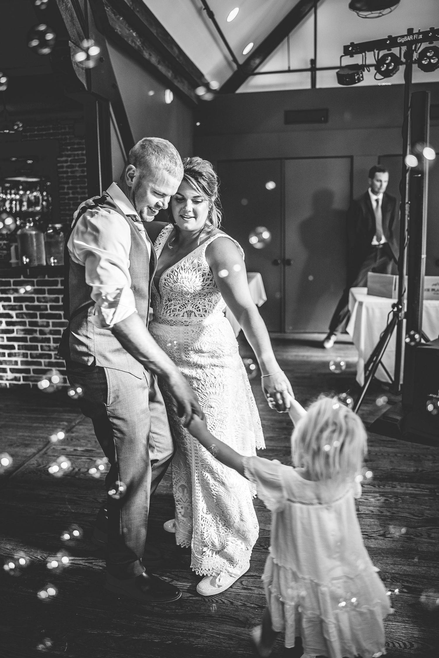 Black and white dance floor moments with guests celebrating at a wedding reception.