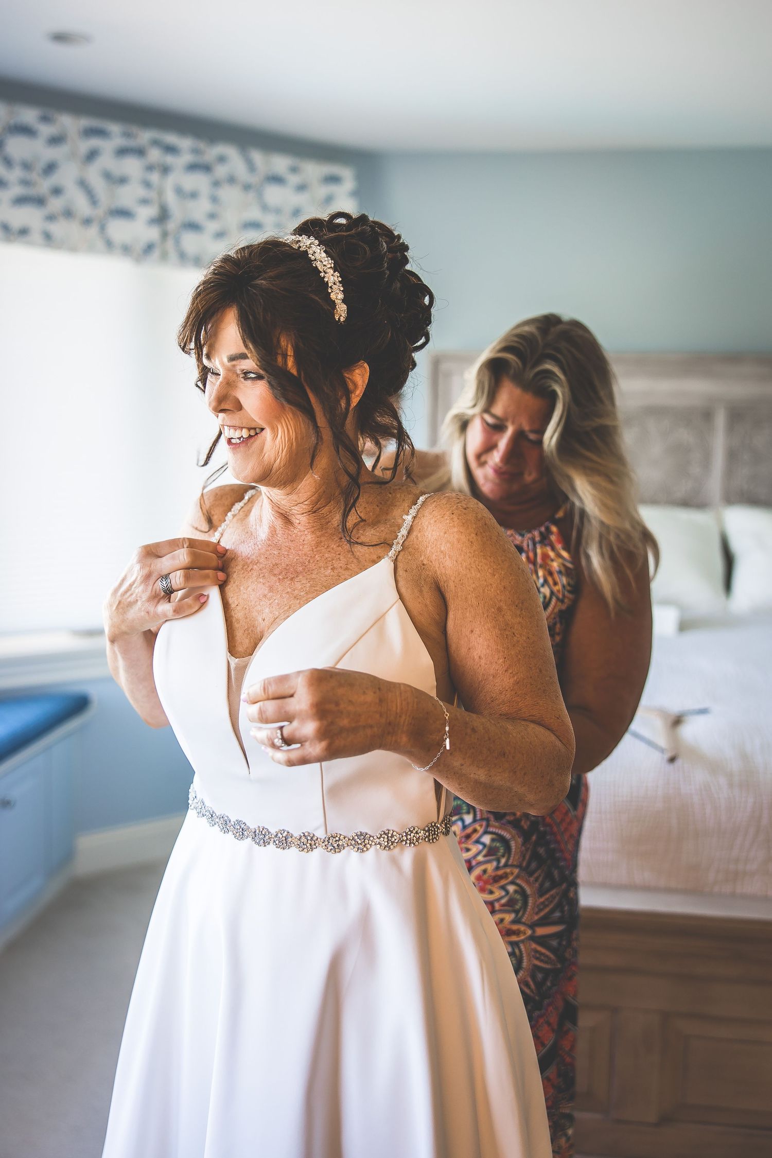 Getting ready scene with white wedding dress in a blue-walled room.
