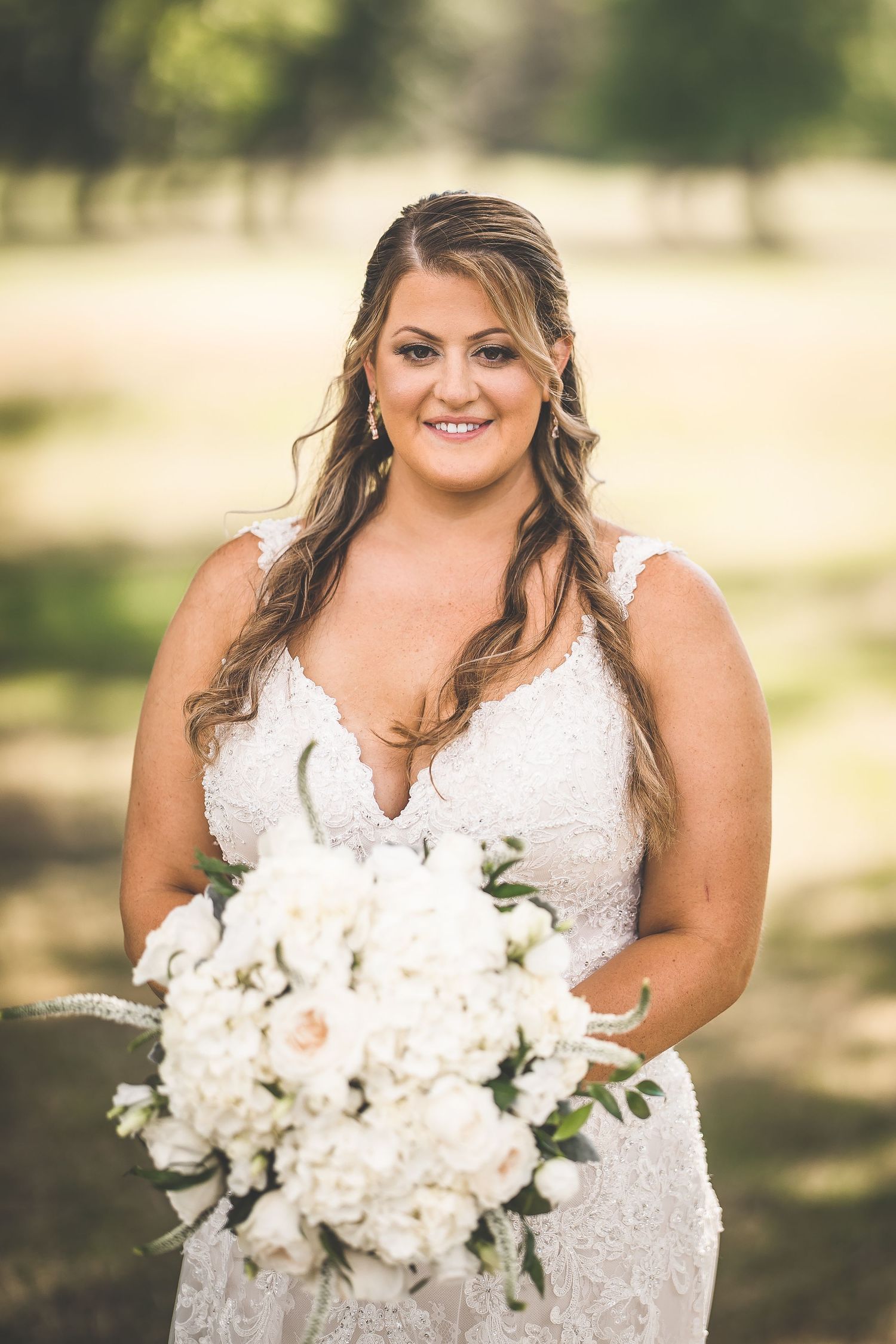 A close-up view of a white lace wedding dress and elegant white floral bouquet.