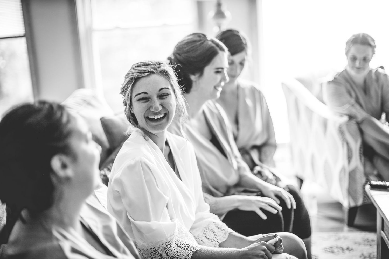 Black and white candid photo of wedding morning preparations with natural window light.