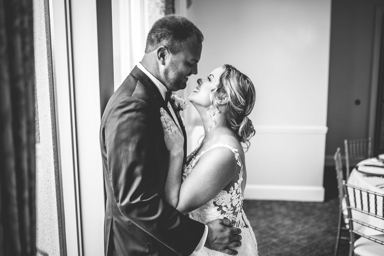 Couple shares romantic moments in elegant indoor venue during wedding celebration.