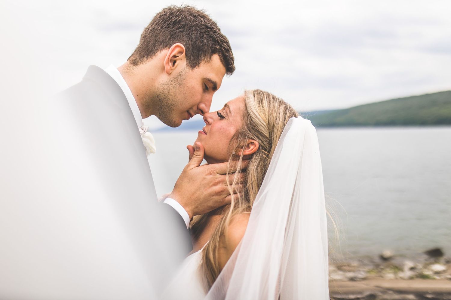 Intimate wedding portraits showcase tender moments between newlyweds against a lakeside backdrop.