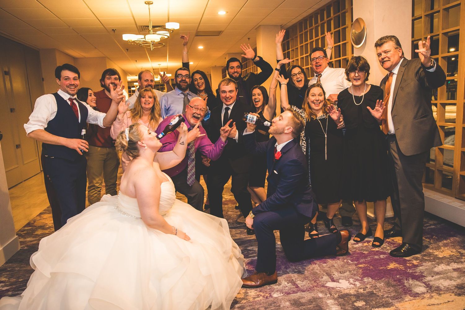 Wedding celebration with guests dancing and socializing in an elegantly lit ballroom venue.