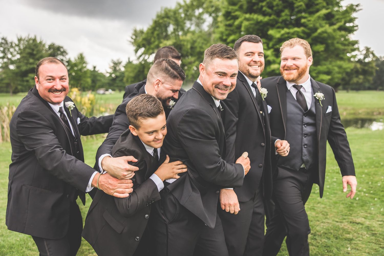 Wedding party laughing and having fun during outdoor photo session.