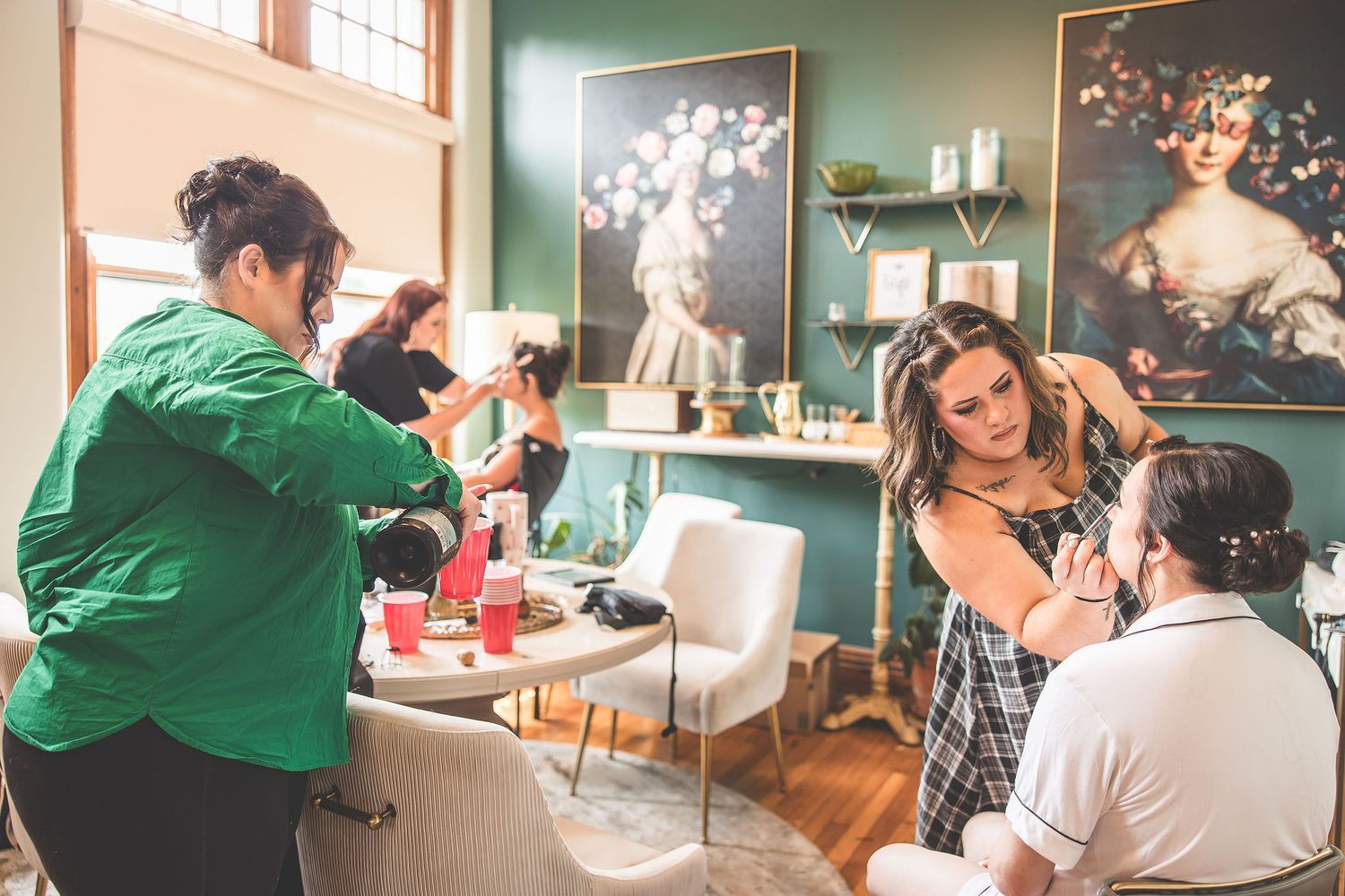 Wedding preparation scene showing details of hair and makeup styling in a green-walled room.