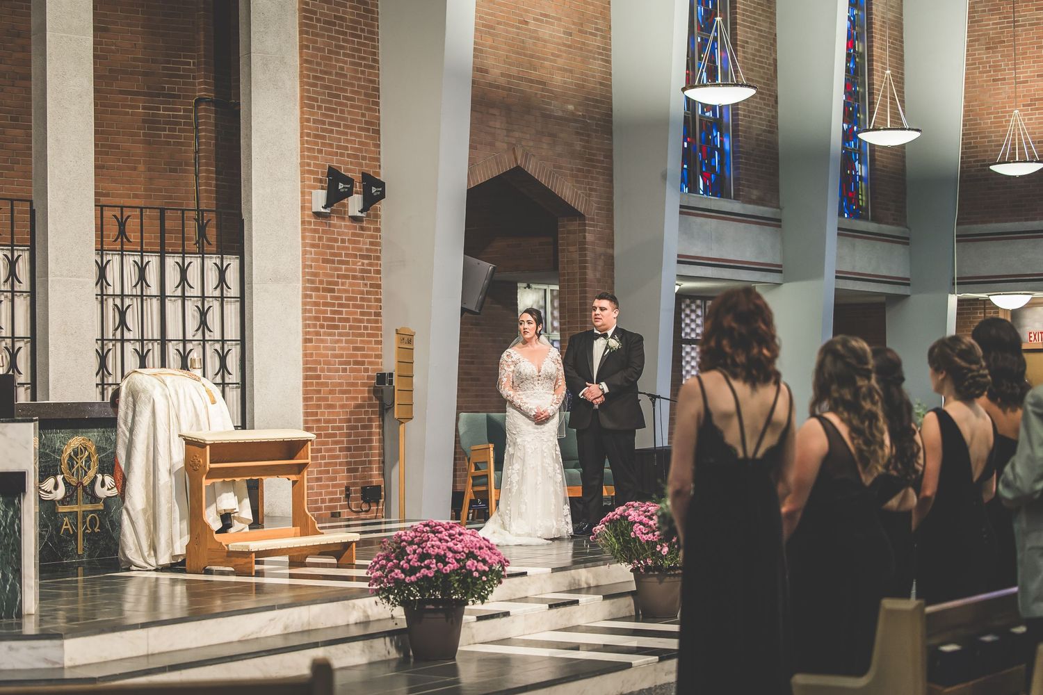 Side view of church interior showing brick walls and decorative iron window details.