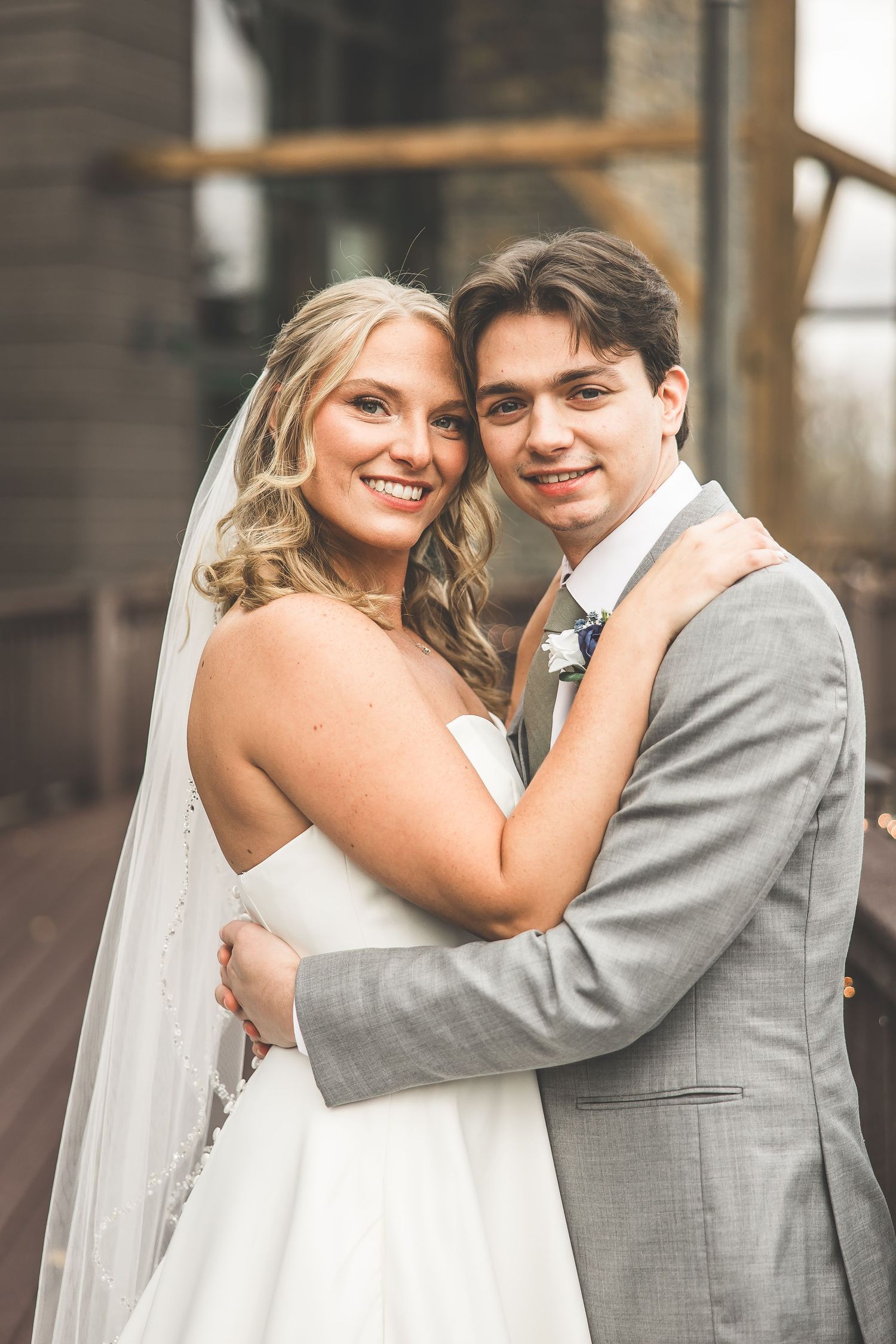 Close-up of wedding couple sharing tender moment on rustic deck.