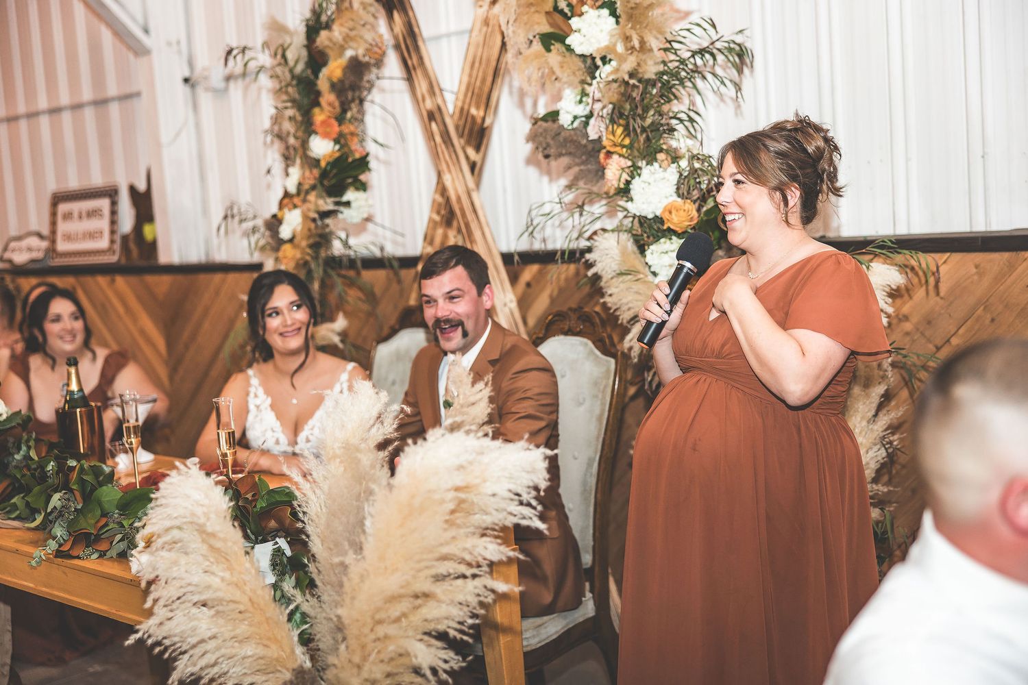 Wedding reception venue adorned with boho-inspired decor and dried pampas grass arrangements.