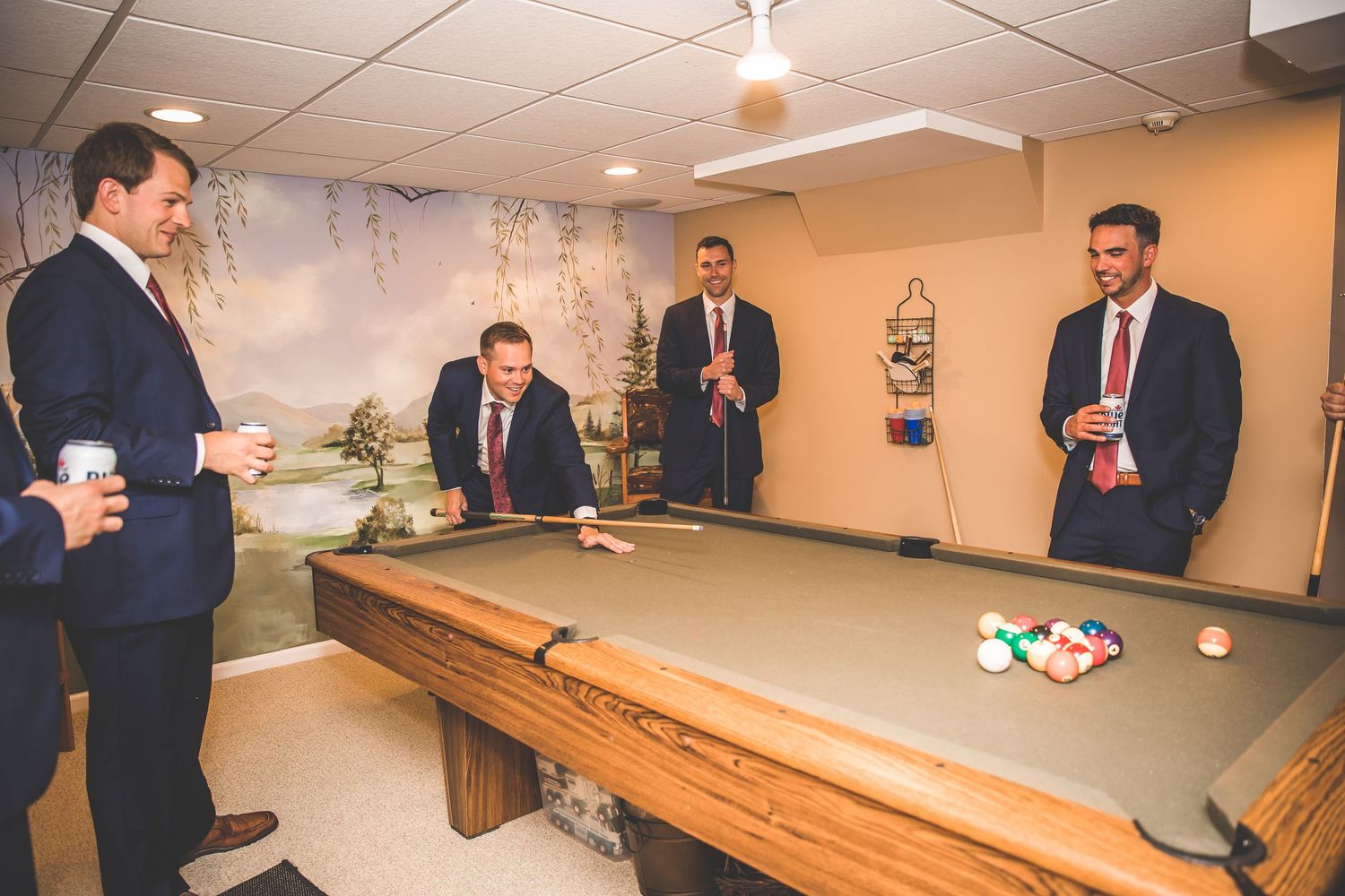 Men in formal attire playing pool and enjoying pre-wedding activities.