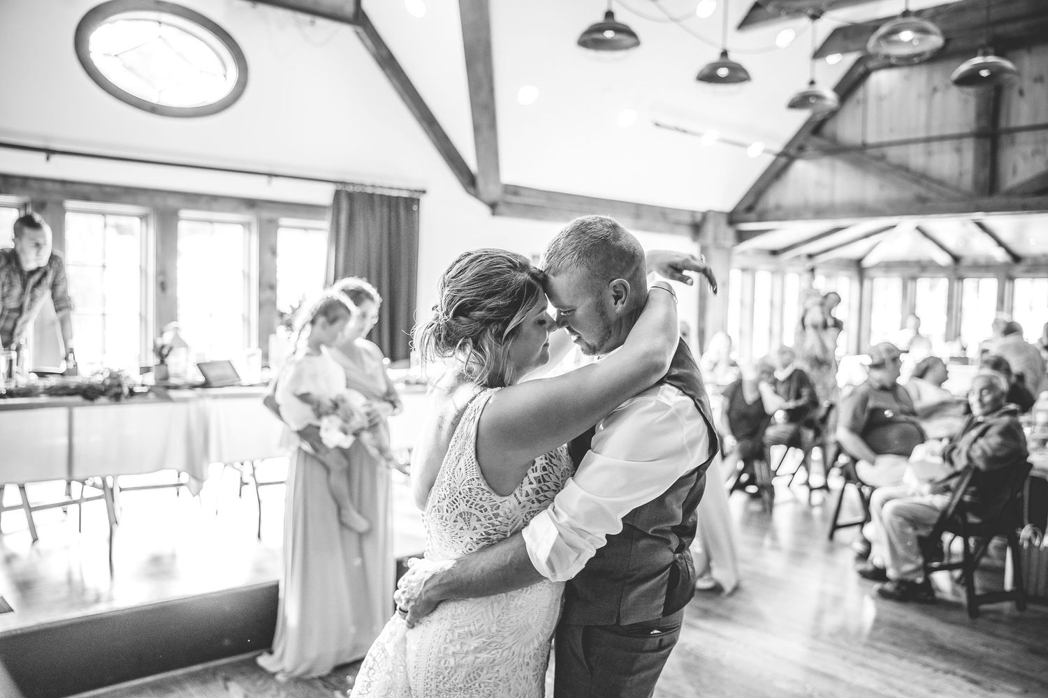 Black and white wedding reception photos showing couples dancing in a bright indoor venue.
