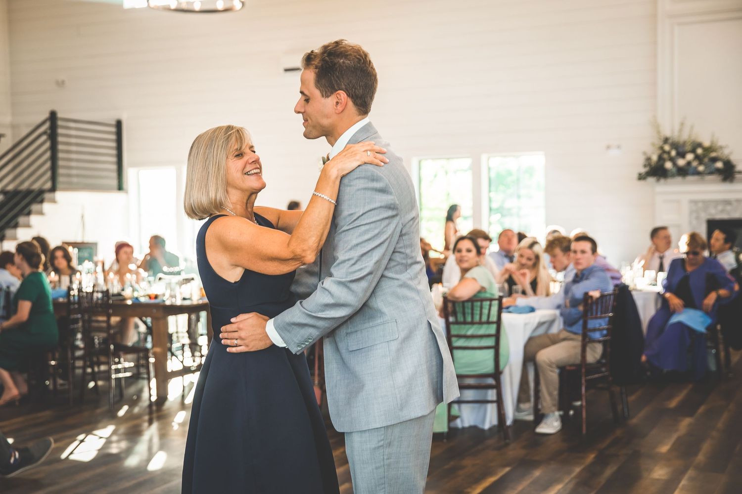 A couple in formal attire dances together during a wedding celebration.