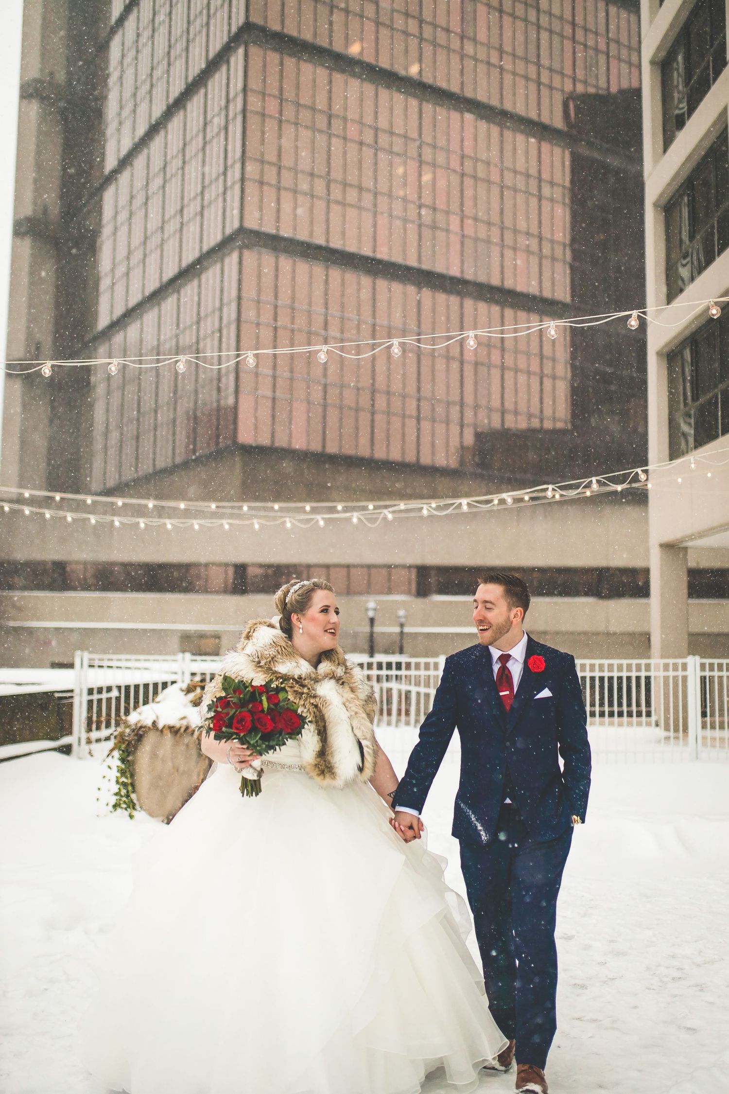 Romantic winter wedding photos with couple walking through falling snow.