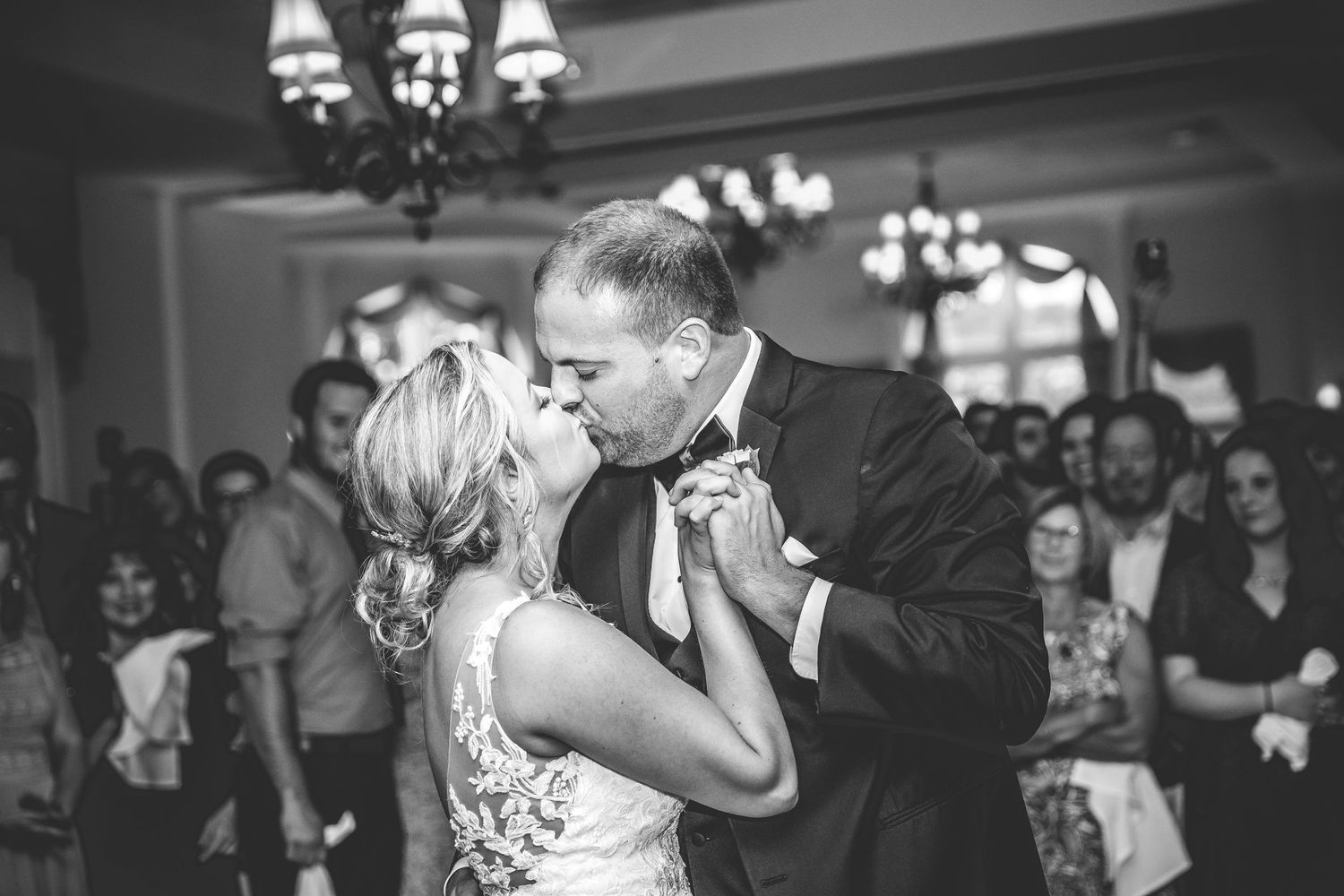 Black and white photo captures an intimate dancing moment at an elegant wedding reception.