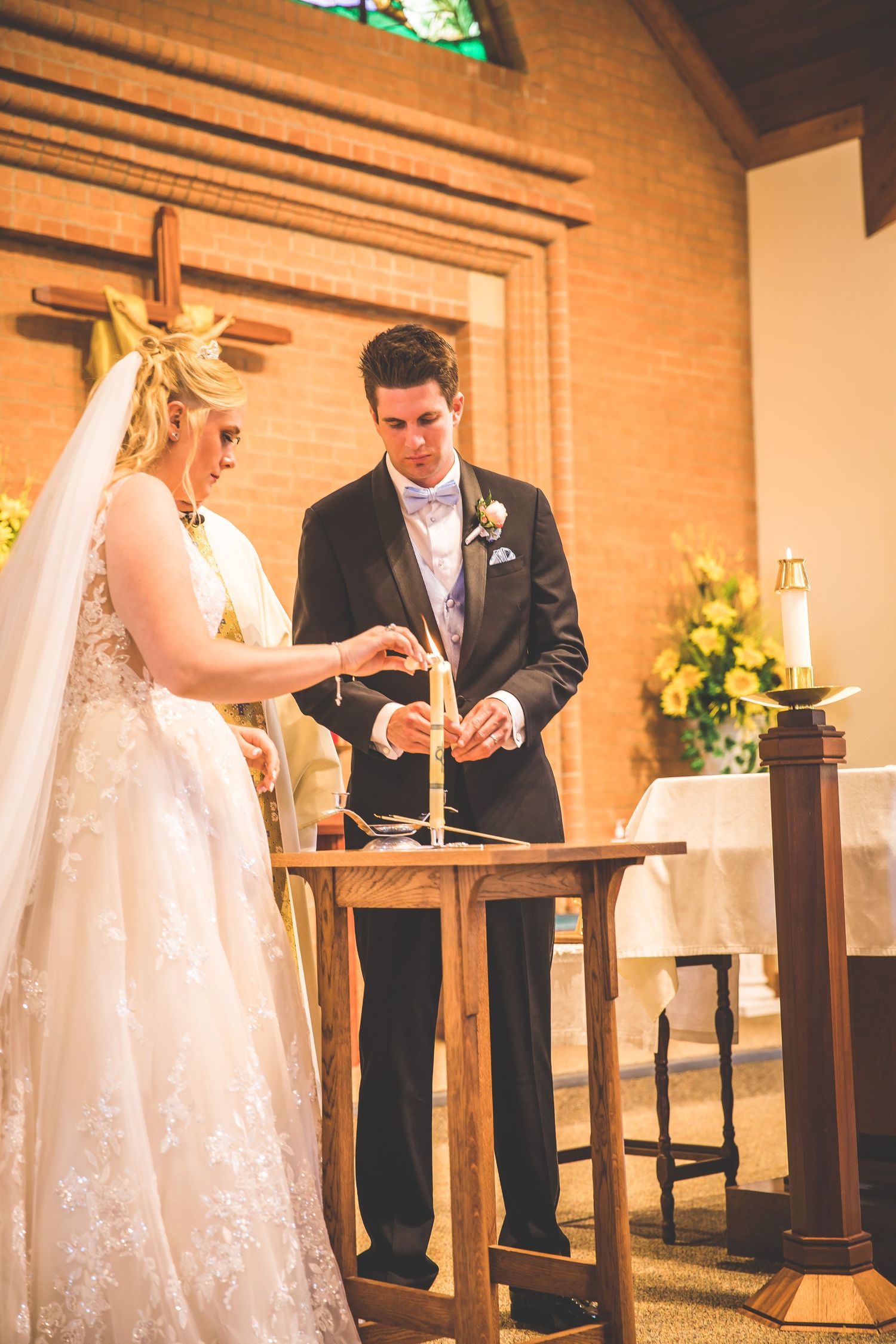 Couple signing documents during wedding ceremony at church altar.