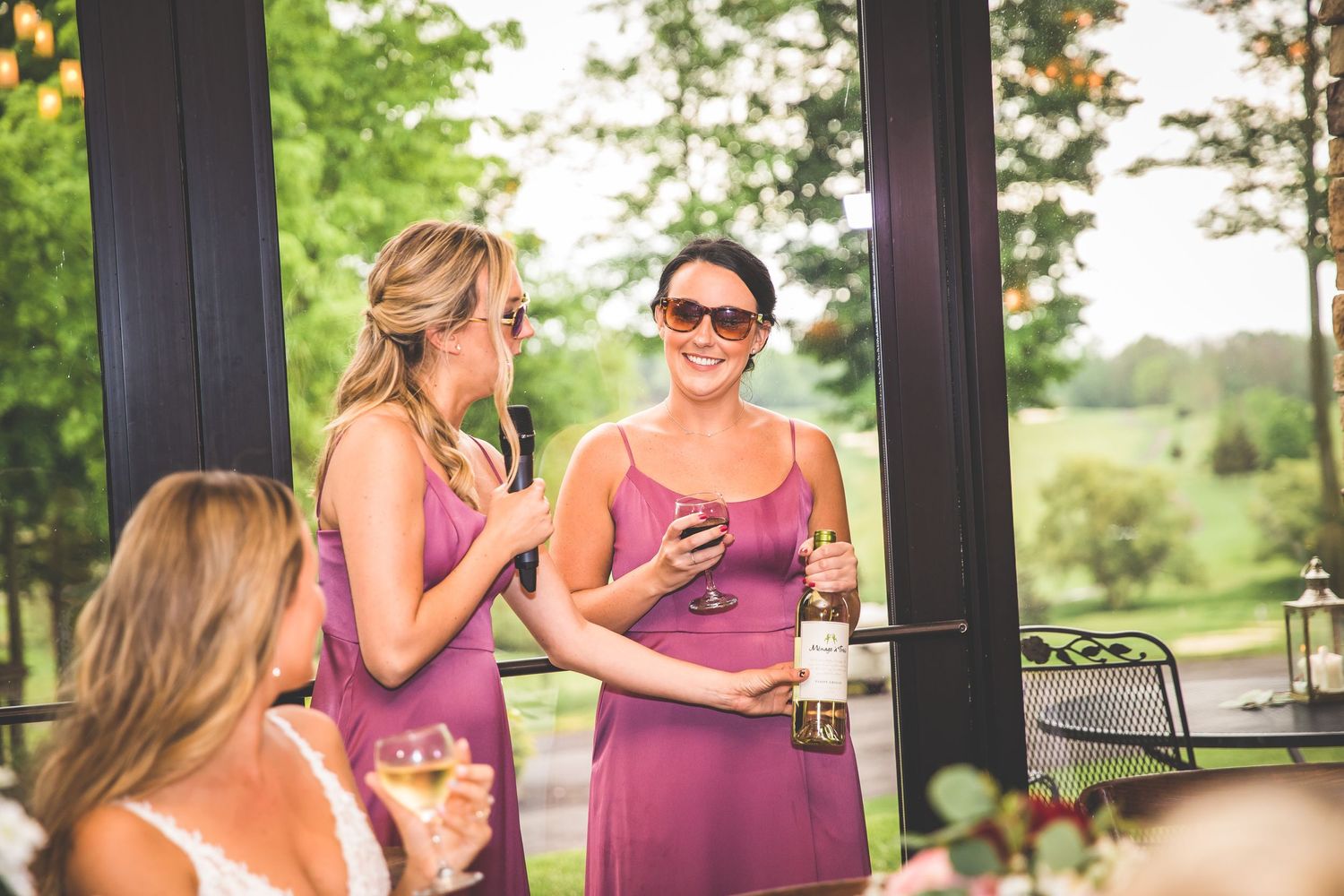 Wedding guests enjoy drinks and conversation on an outdoor patio during a summer celebration.