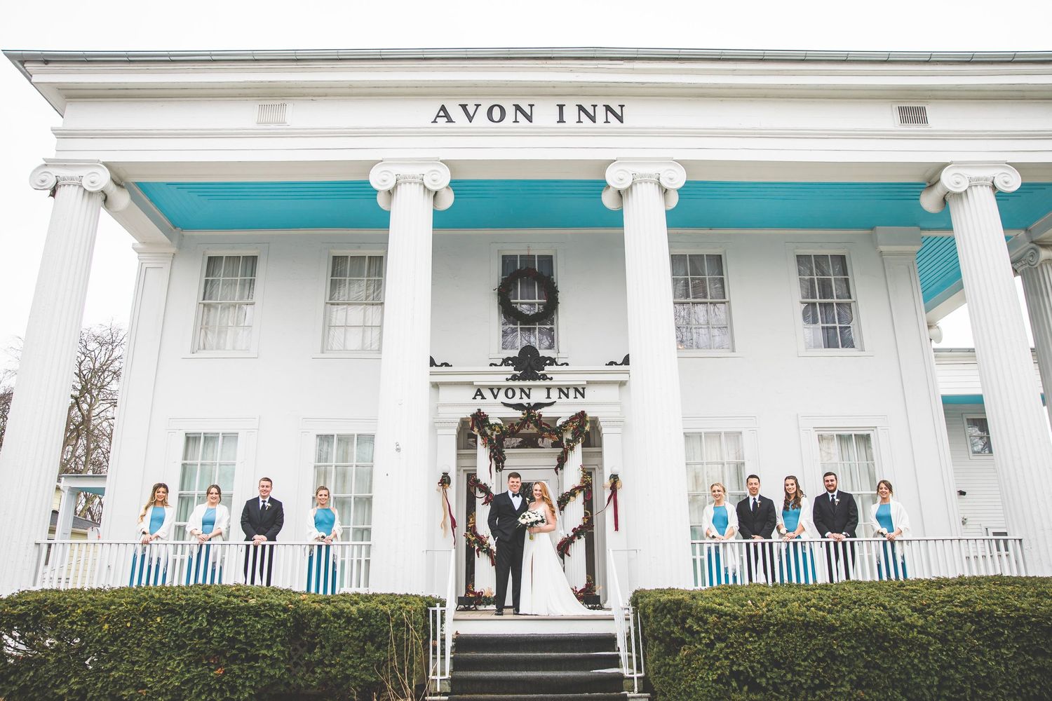 An exterior view of the Avon Inn with its grand white columns and turquoise accents.