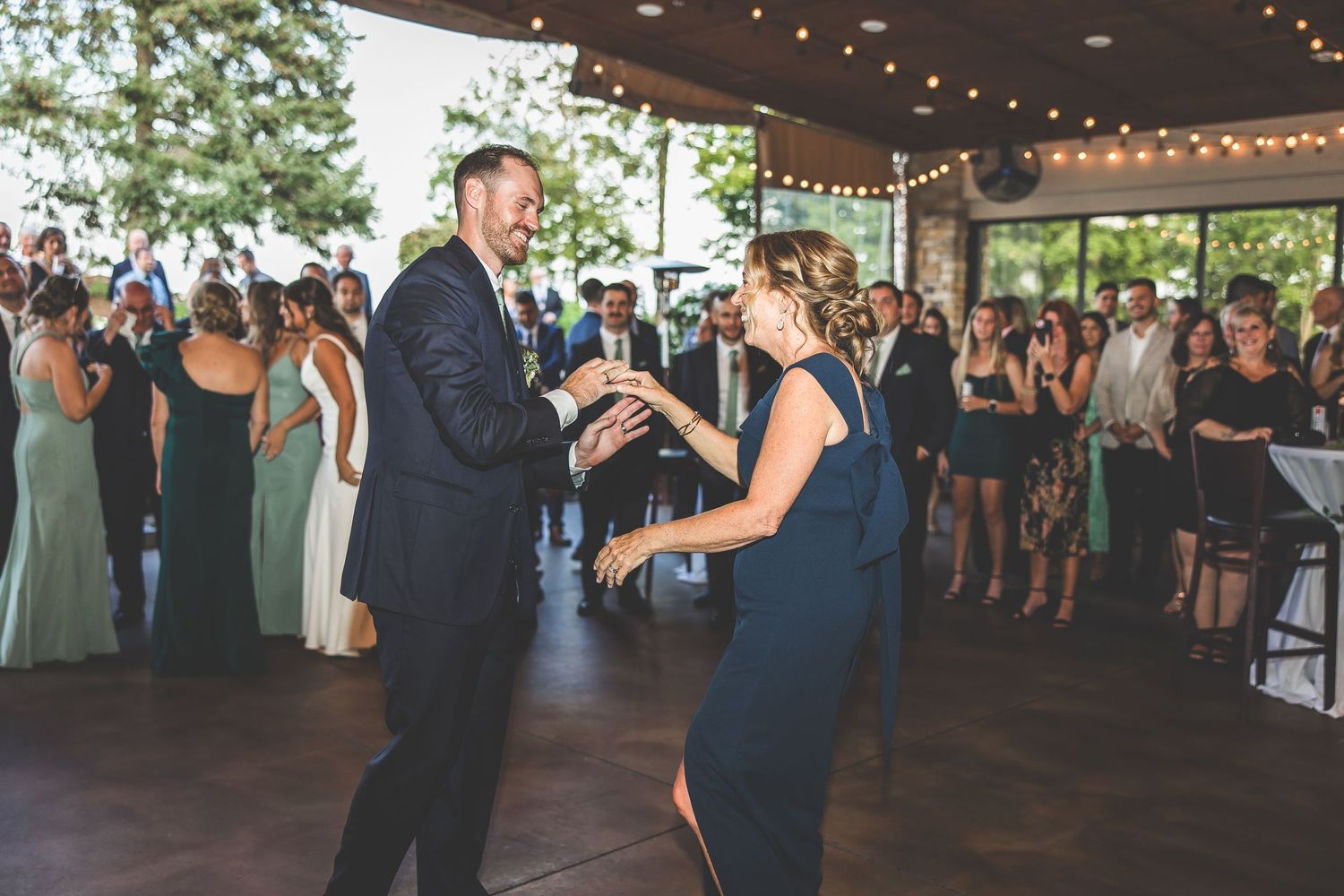 Wedding guests watching the dance floor during an evening reception.