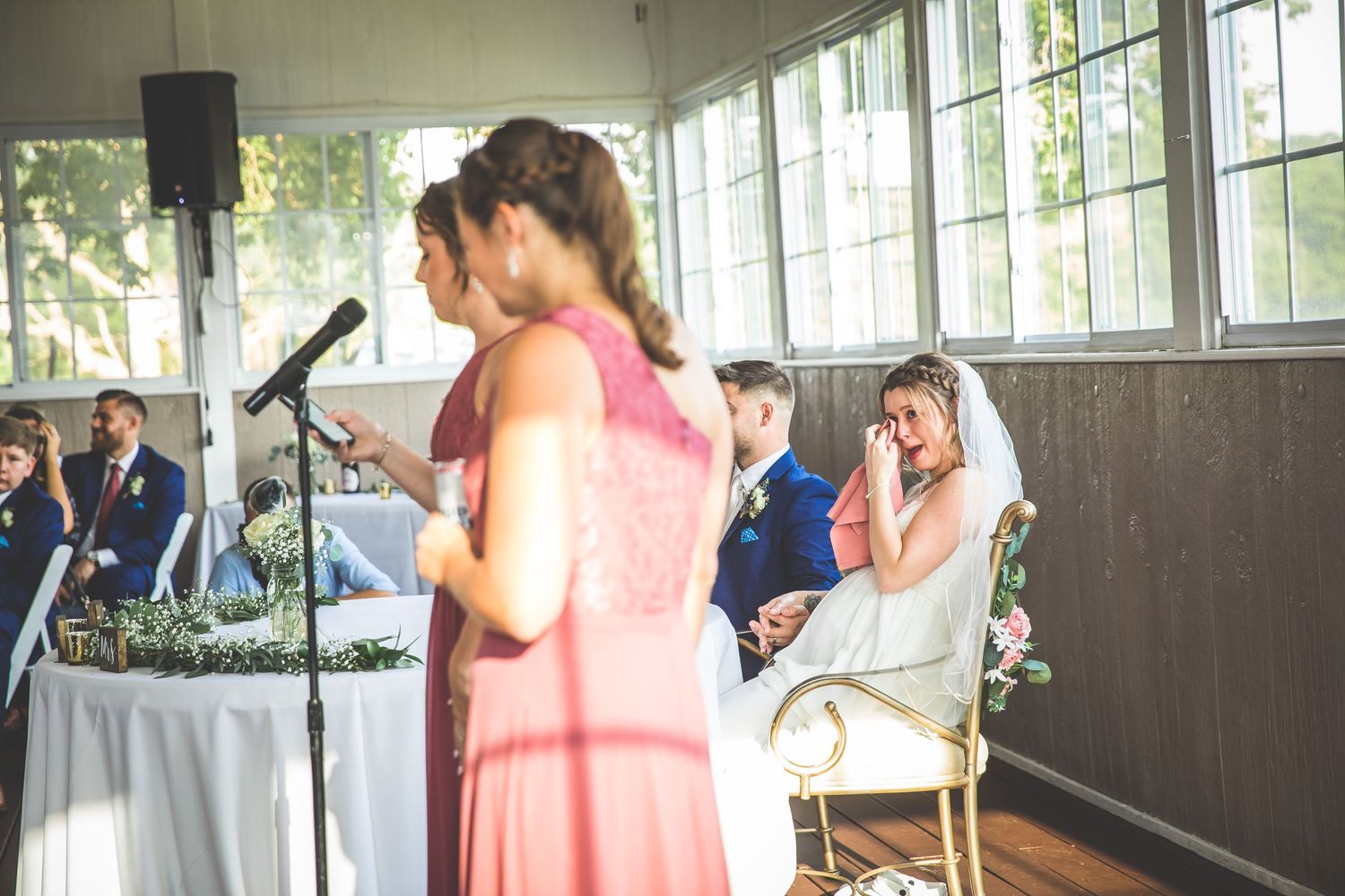 Modern wedding reception space with industrial windows and romantic lighting.