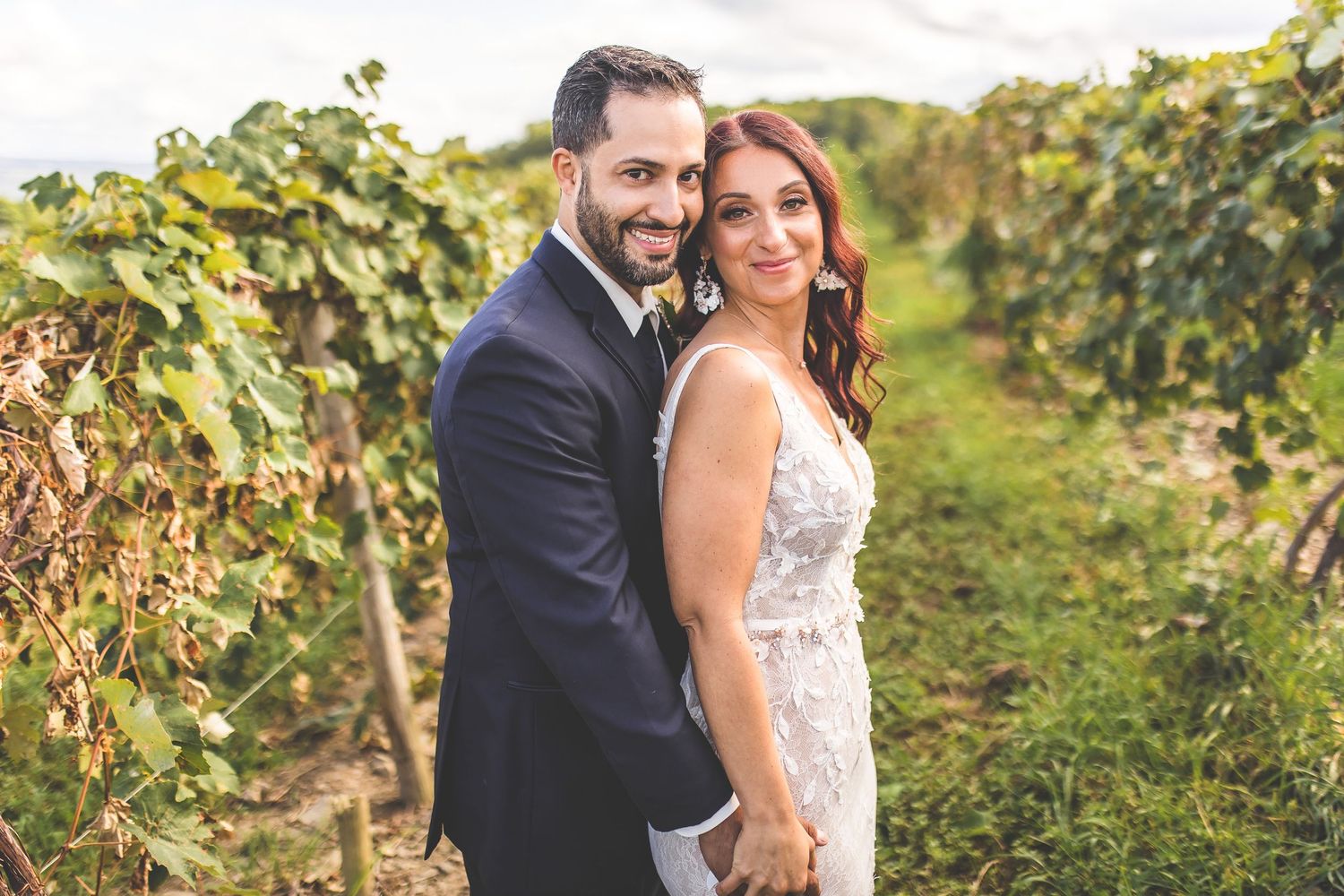 Romantic wedding photos taken in a lush vineyard setting during late afternoon light.