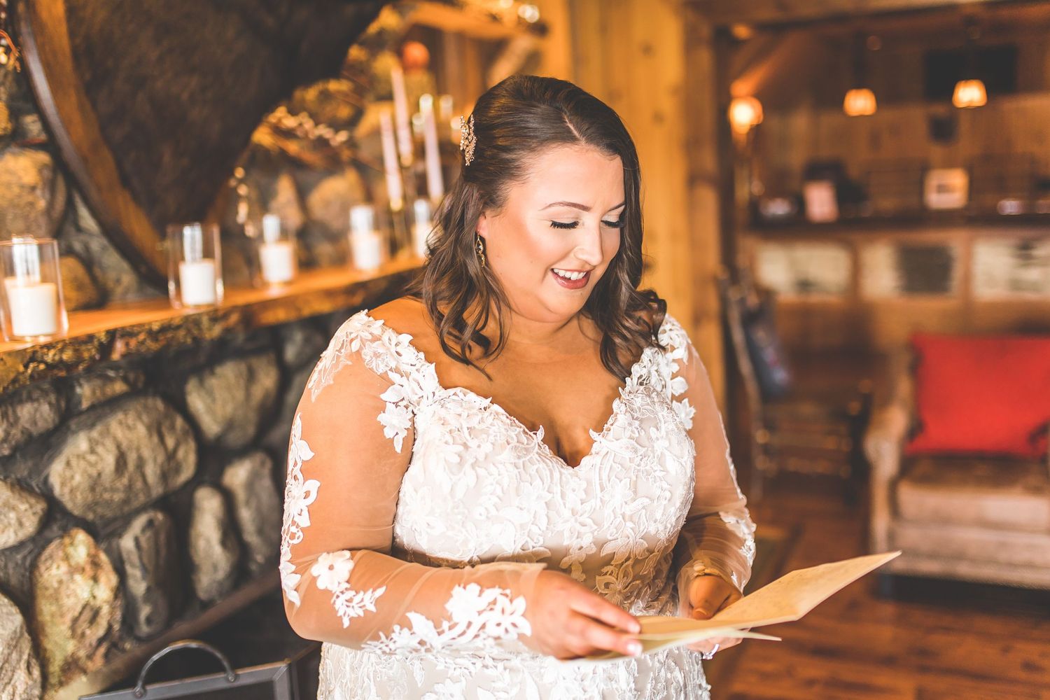 Bride in a white lace dress posing in a rustic indoor setting.