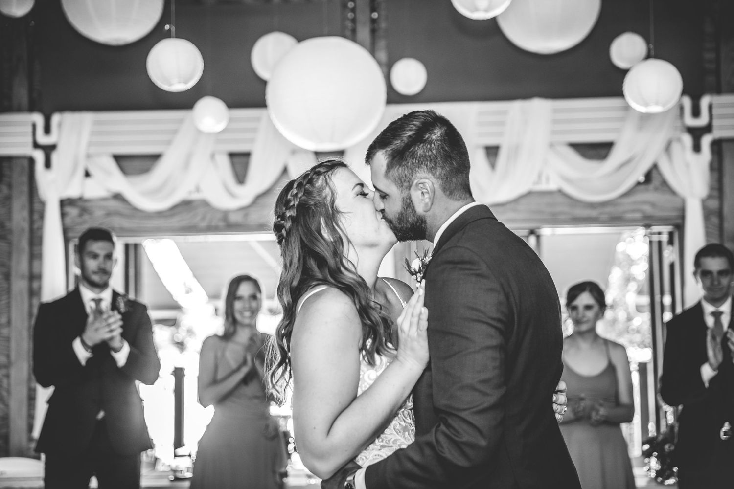 Wedding reception dance captured in black and white under decorative paper lanterns.