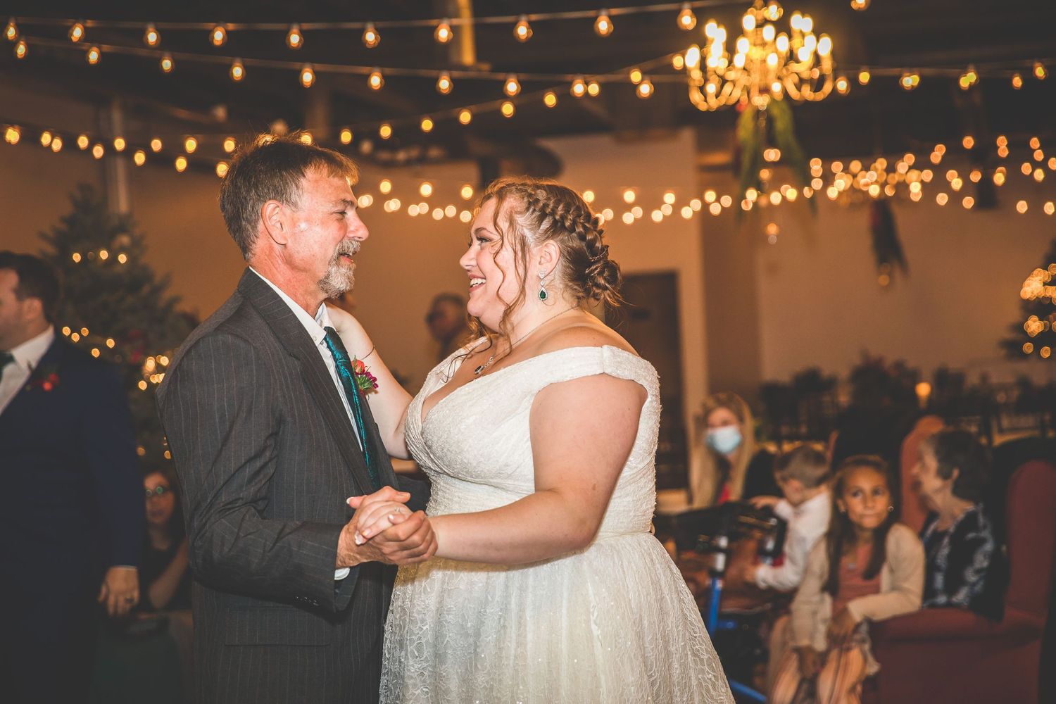 Romantic dance floor scene with string lights and chandeliers creating warm ambiance.
